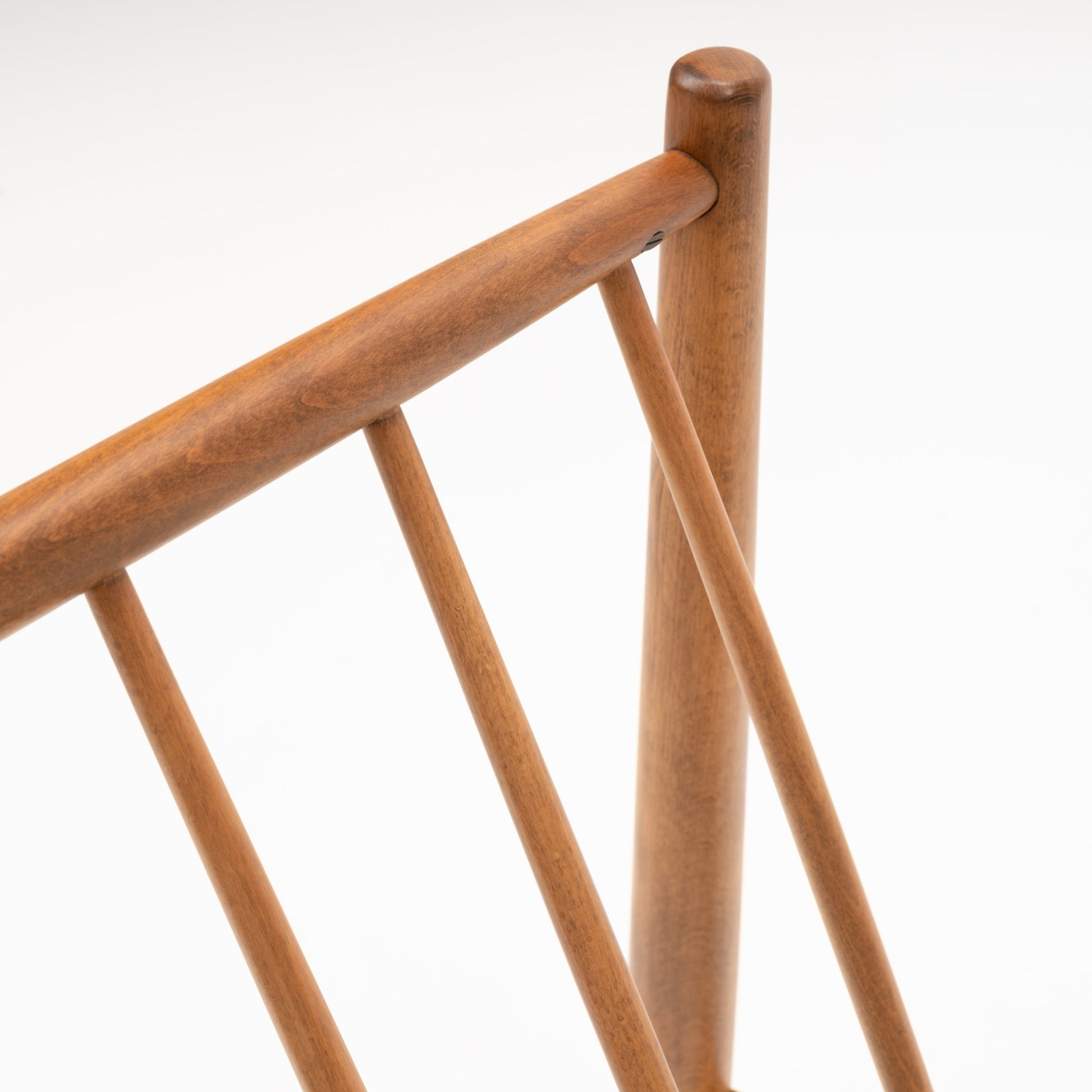 Close-up of Folke Ohlsson slipper lounge chair showing angled beechwood frame with smooth rounded posts and slats