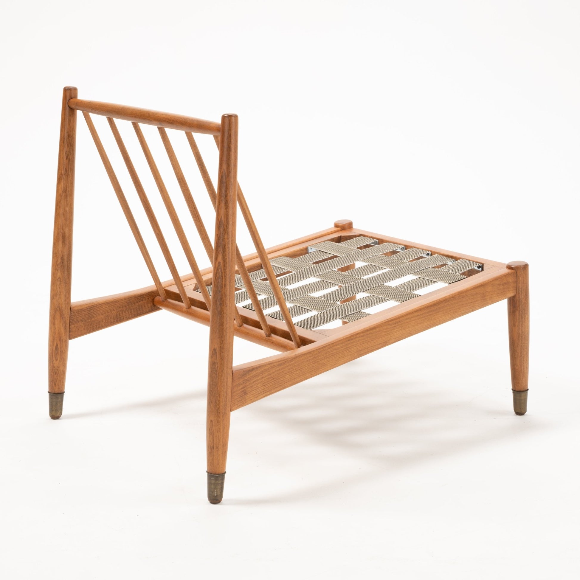 Angled view of Folke Ohlsson slipper lounge chair frame with beechwood slats and woven seat support without cushions