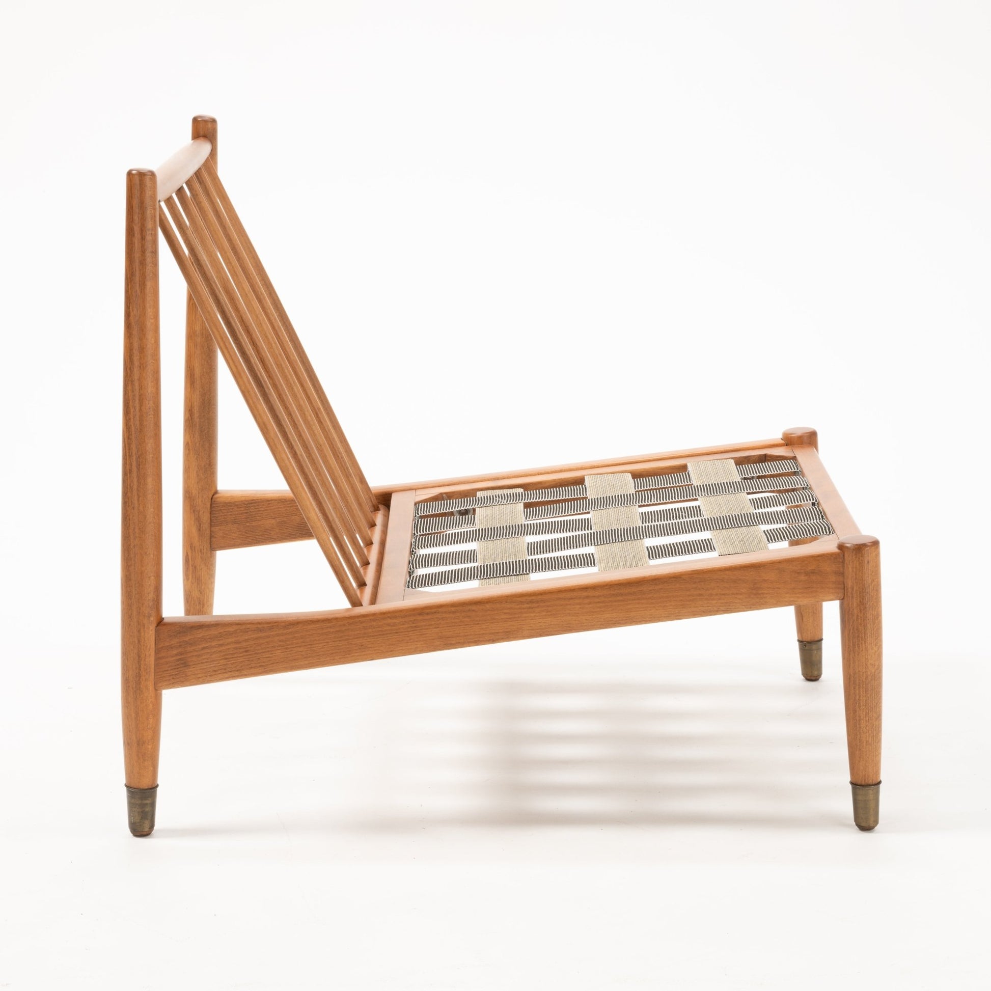 Side view of Folke Ohlsson slipper lounge chair frame showing slatted beechwood back and woven seat support