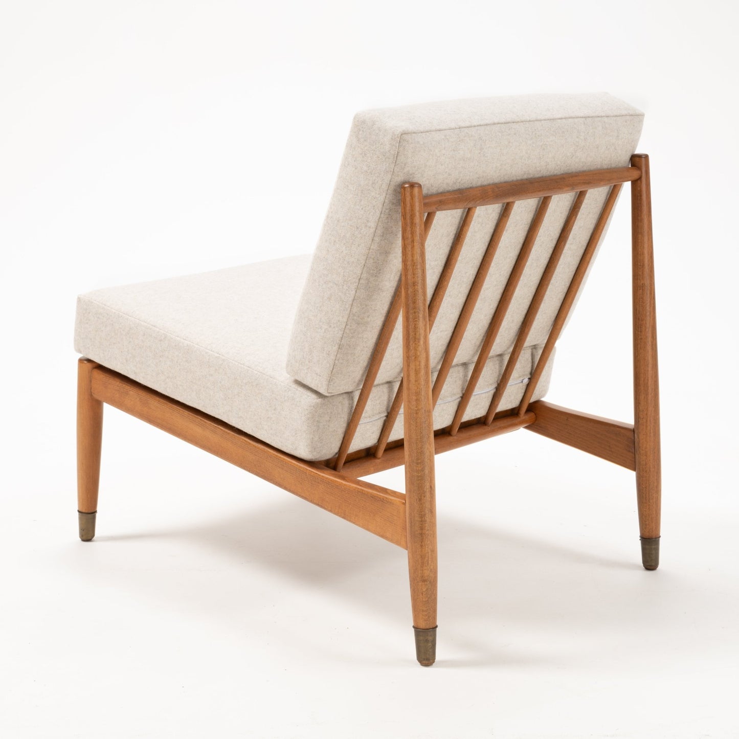 Rear angled view of Folke Ohlsson slipper chair showing beechwood frame with vertical slats and light beige upholstered cushions