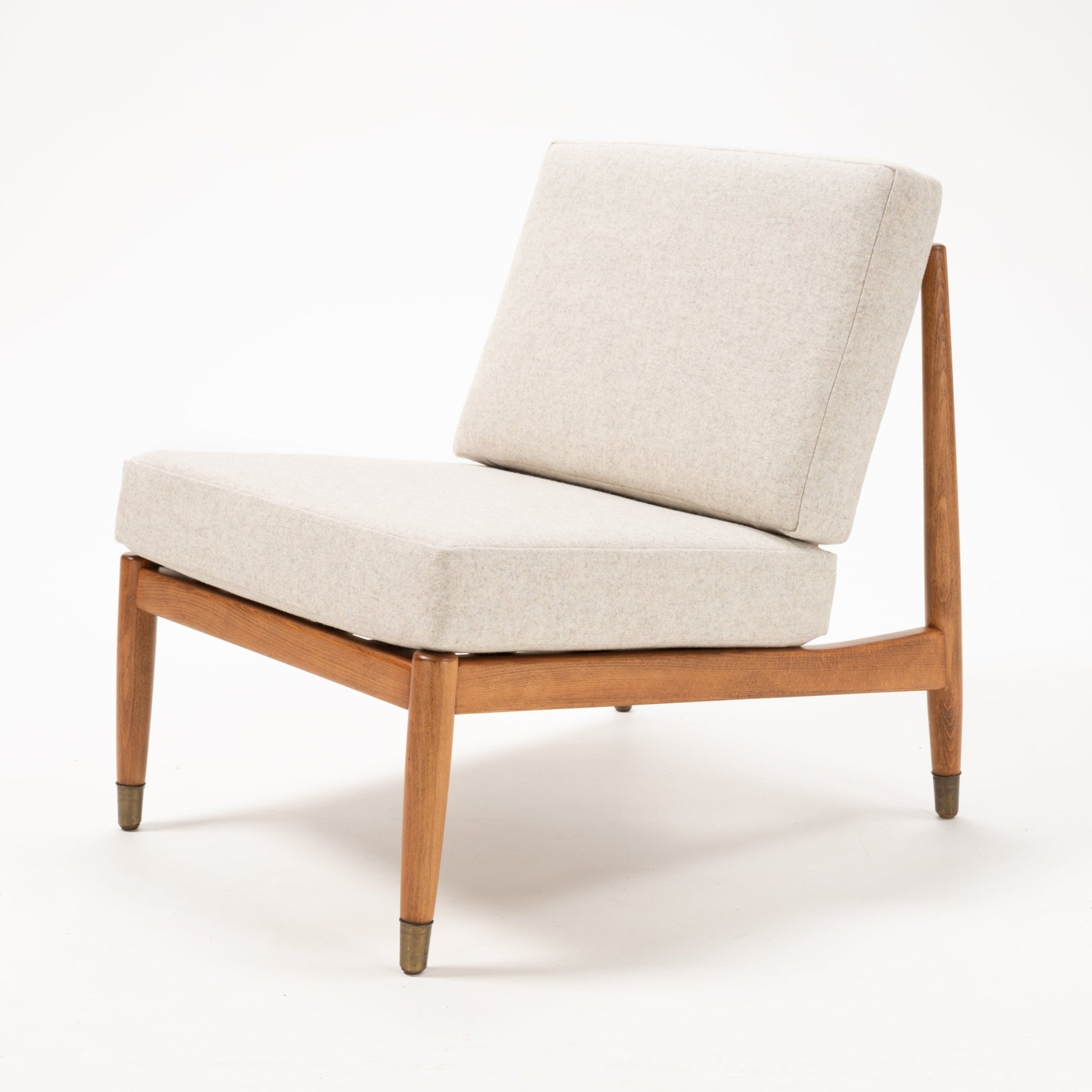 Folke Ohlsson armless slipper lounge chair with beige cushions and teak-beechwood frame on white background