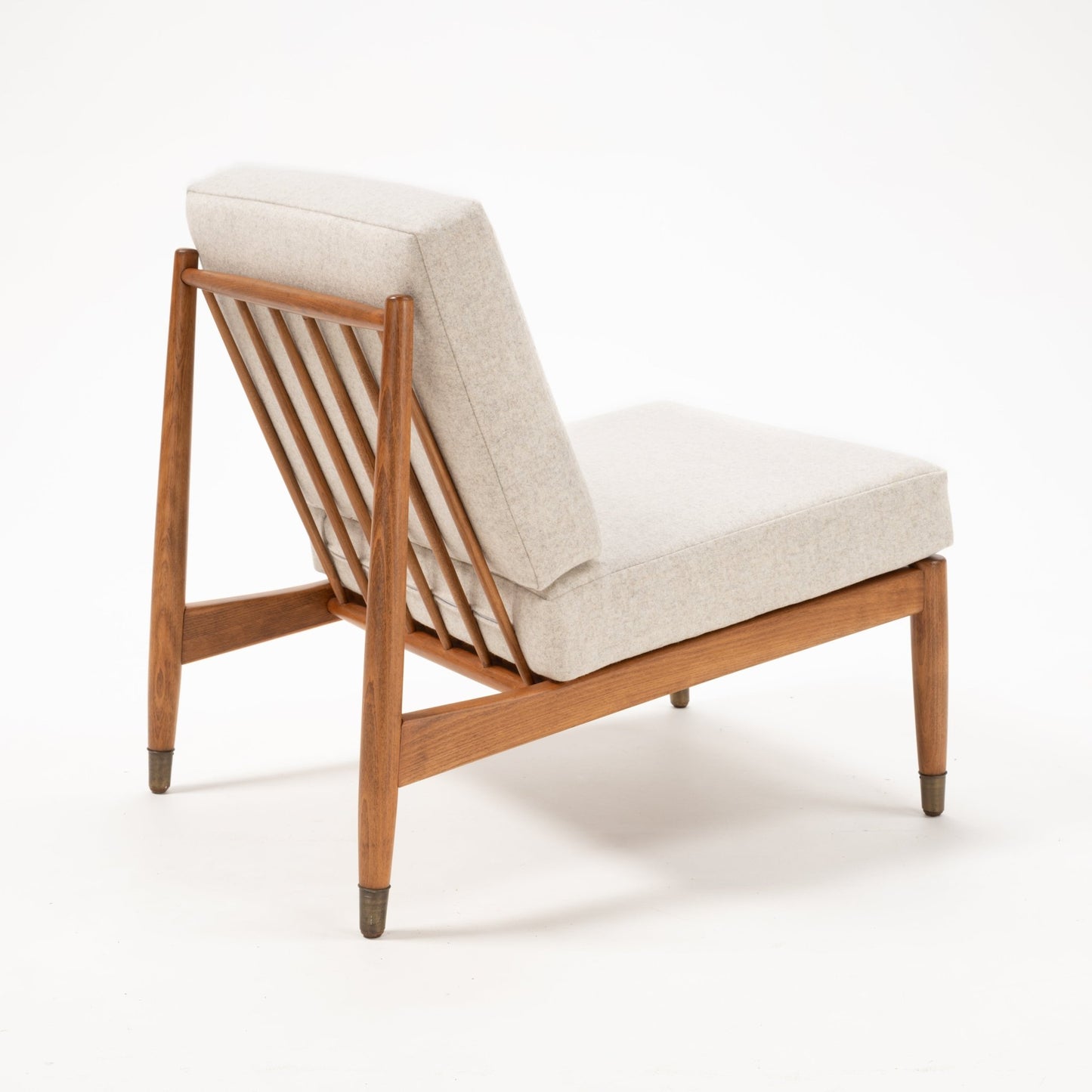 Armless Folke Ohlsson slipper lounge chair with beige cushions and slatted teak and beechwood frame on white background