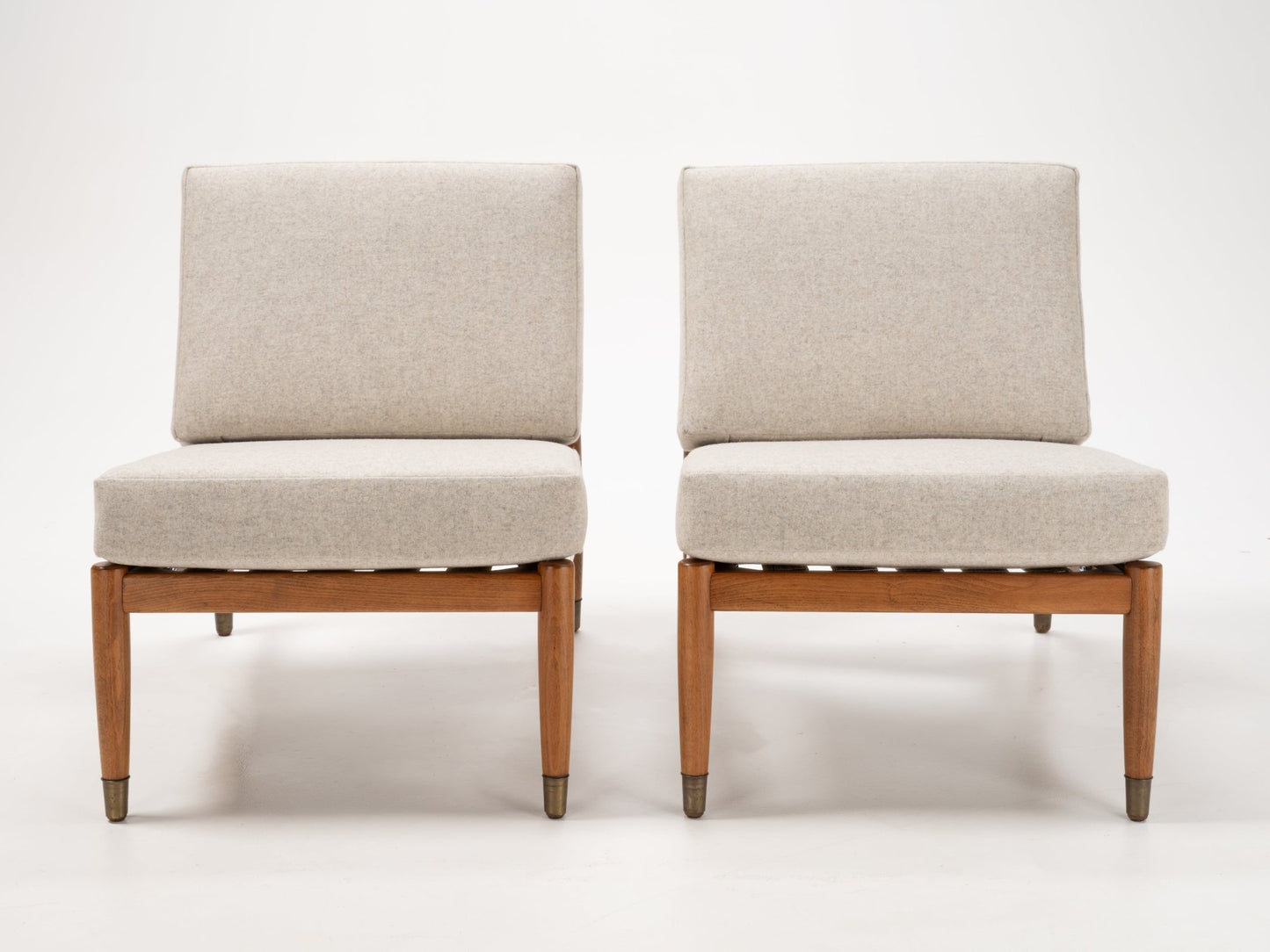 Pair of Folke Ohlsson slipper lounge chairs with beige cushions and teak-toned beechwood frames with metal-capped legs