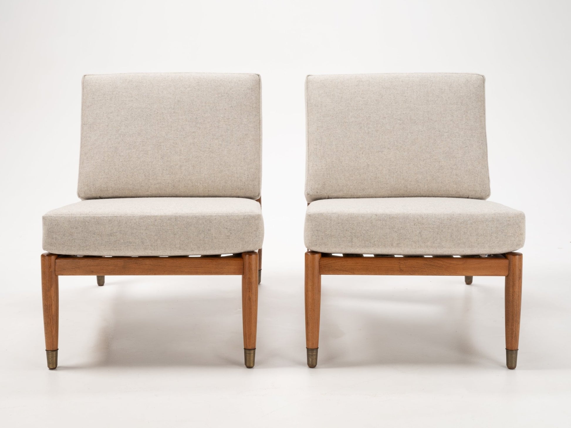 Pair of Folke Ohlsson slipper lounge chairs with beige cushions and teak-toned beechwood frames with metal-capped legs