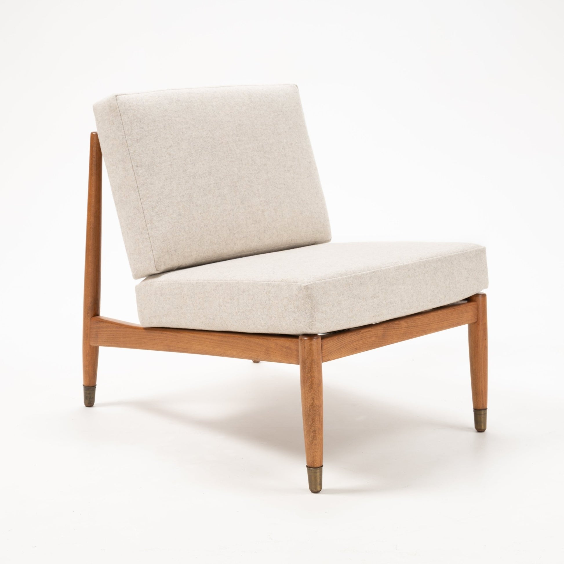 Mid-century Folke Ohlsson slipper chair with beige cushions and teak wood frame on white background