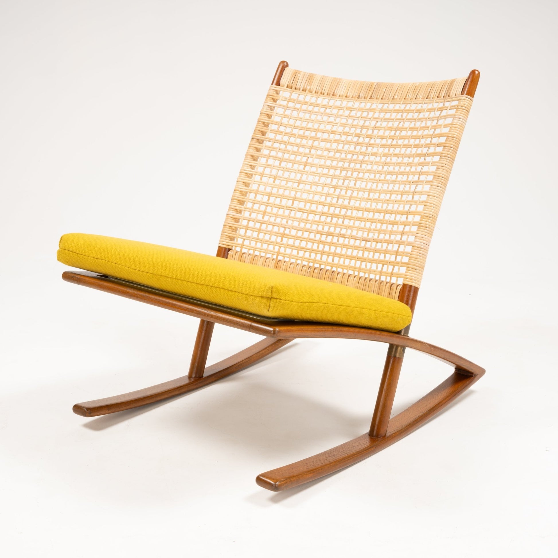 Low angle of Fredrik Kayser Model 599 rocking chair with woven seatback, teak frame, and bright yellow wool cushion