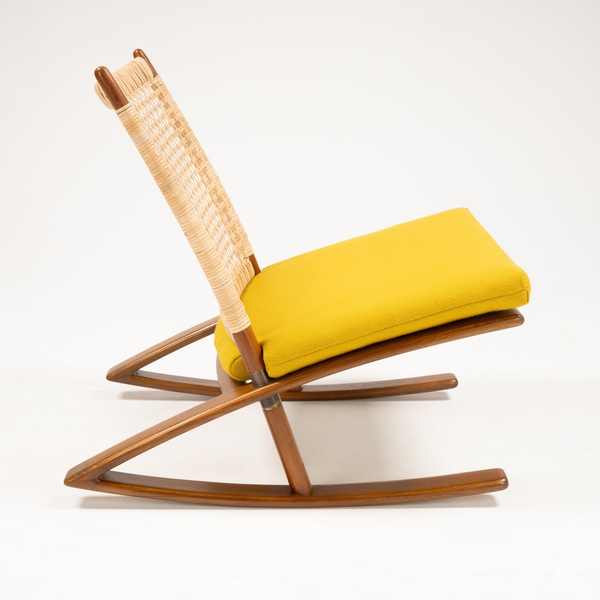 Side profile of Fredrik Kayser Model 599 rocking chair with woven backrest, teak frame, and bright yellow wool cushion