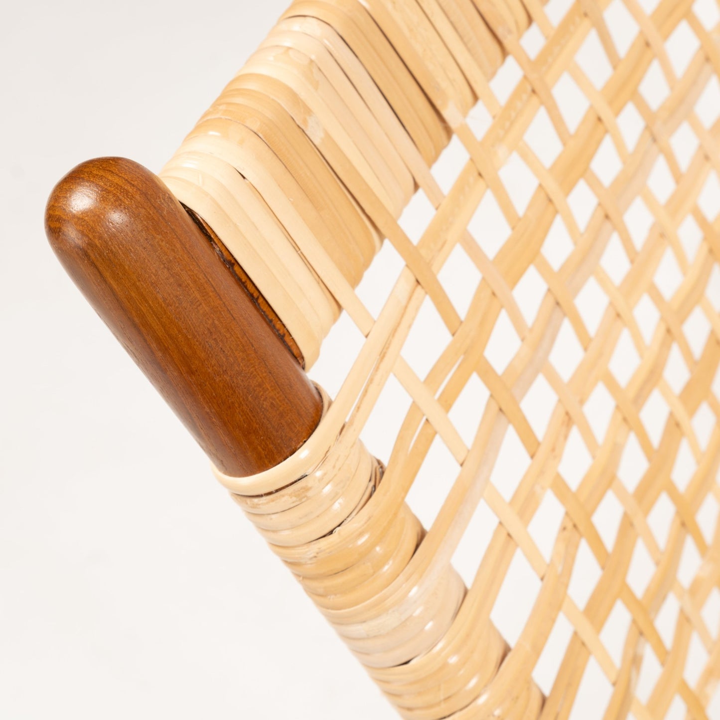 Close-up of woven cane detail with smooth honey-toned teak frame and rounded armrest on Fredrik Kayser Model 599 chair