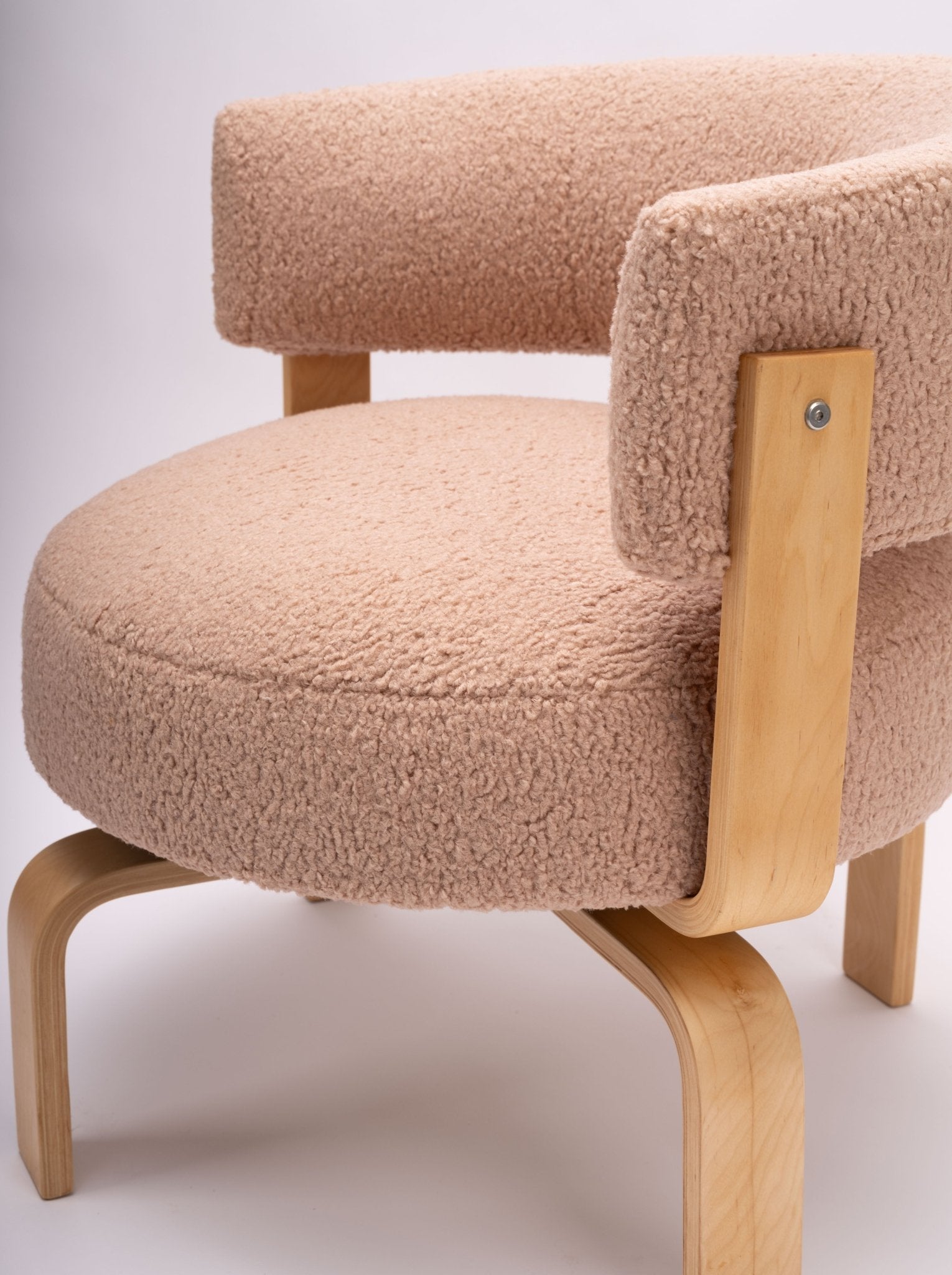 Mid-century modern Fridene swivel chair with curved faux sheepskin upholstery and beechwood frame on white background