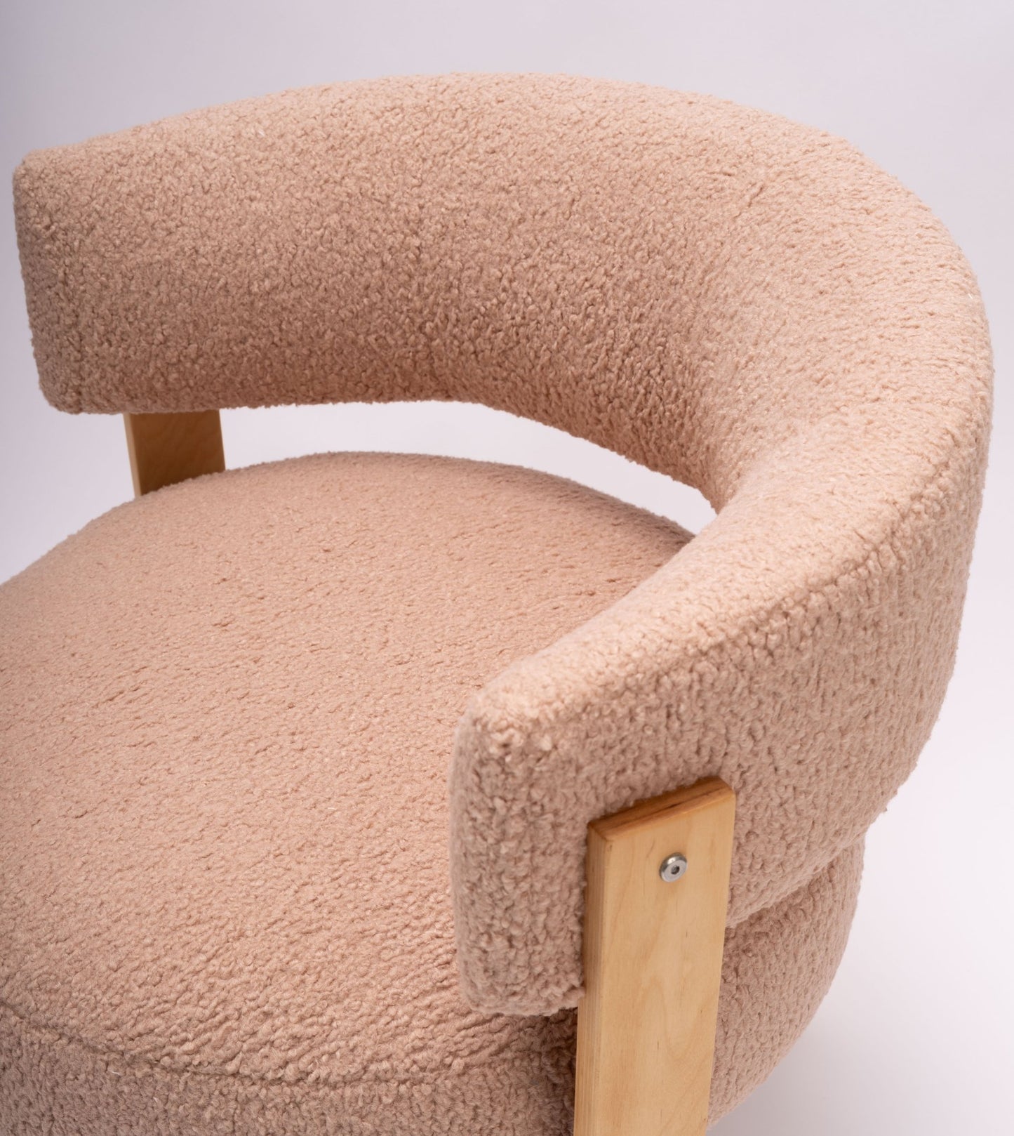 Close-up of Fridene swivel chair with beige faux sheepskin upholstery and light beechwood frame on white background.