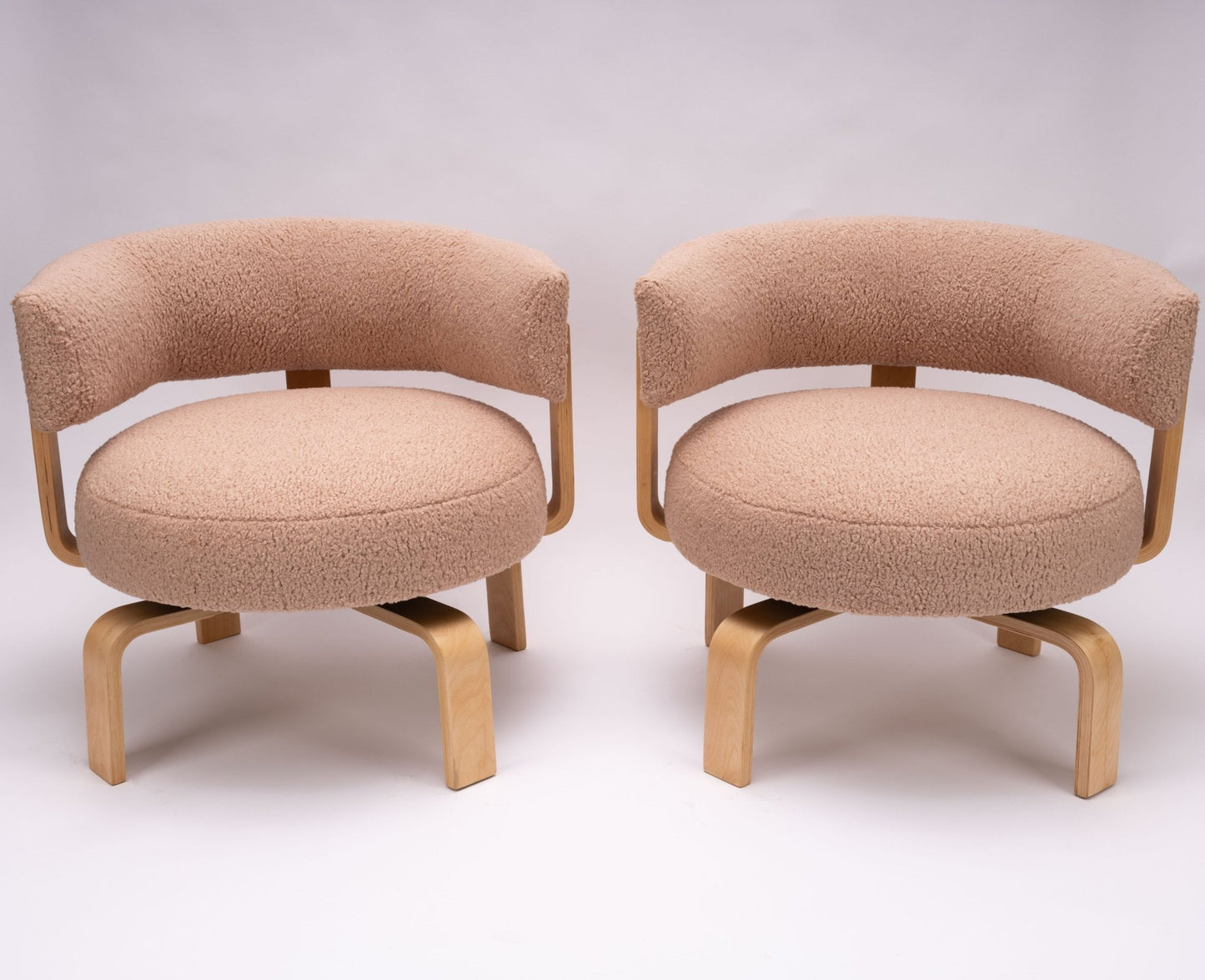 Pair of 2000s Fridene swivel armchairs by Carina Bengs with faux sheepskin seats and beechwood frames on white background.