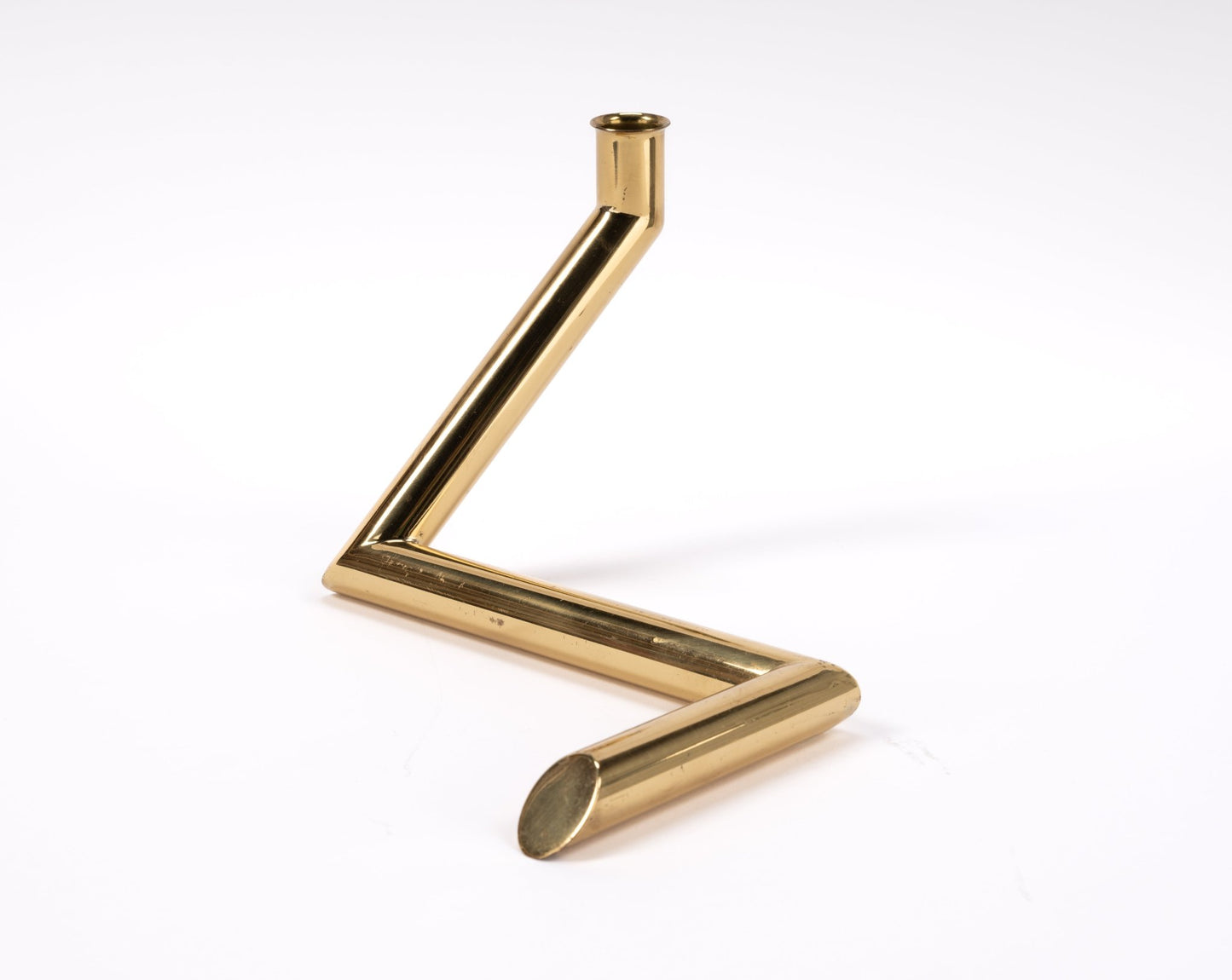 1970s Danish Go Products polished brass candle holder with angular zigzag tubular design on white background