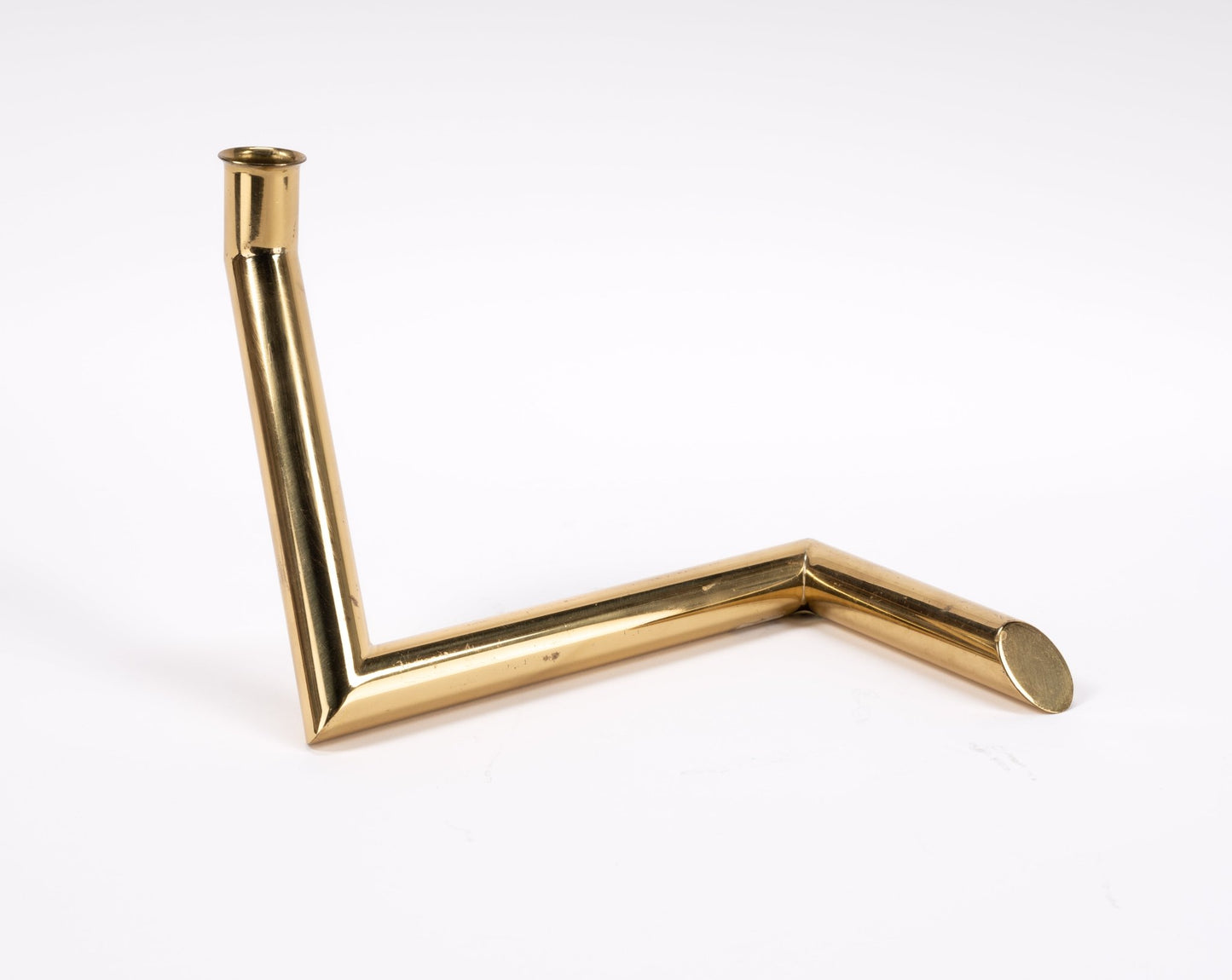1970s Danish Go Products polished brass candle holder with angular zigzag tubular design on white background