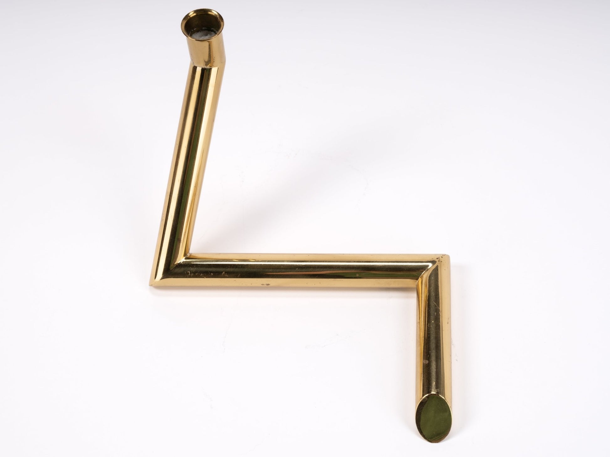 1970s Danish Go Products brass candle holder with polished finish and angular zigzag tubular design on white background