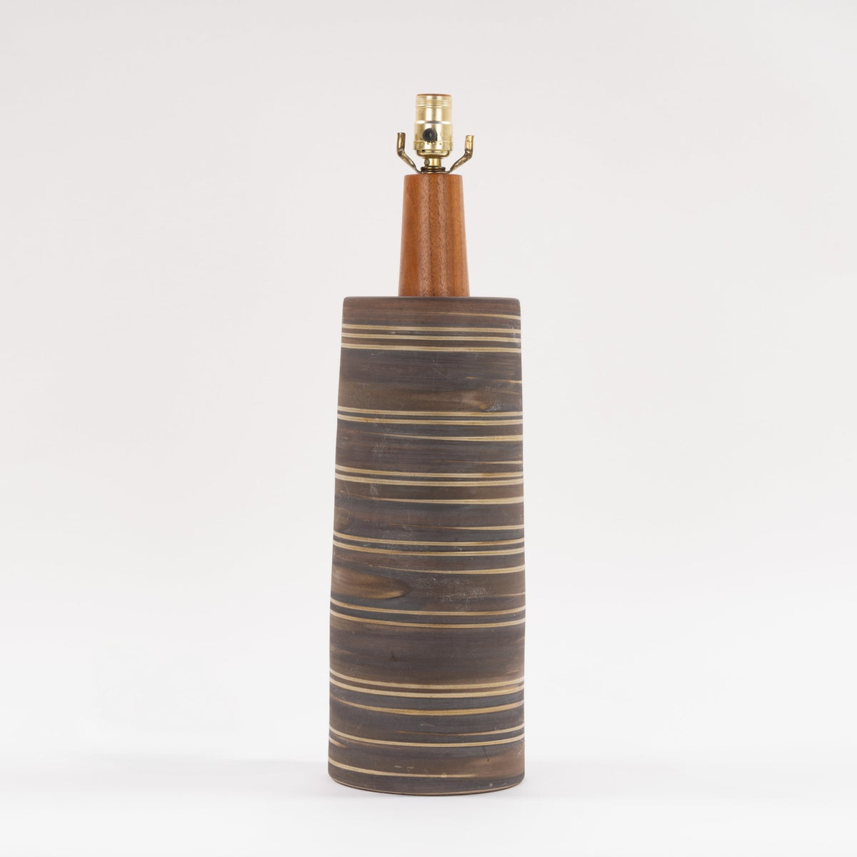 Gordon & Jane Martz Table Lamp with a tall dark striped ceramic base and warm wood neck shown against a white background in mid century modern lighting style