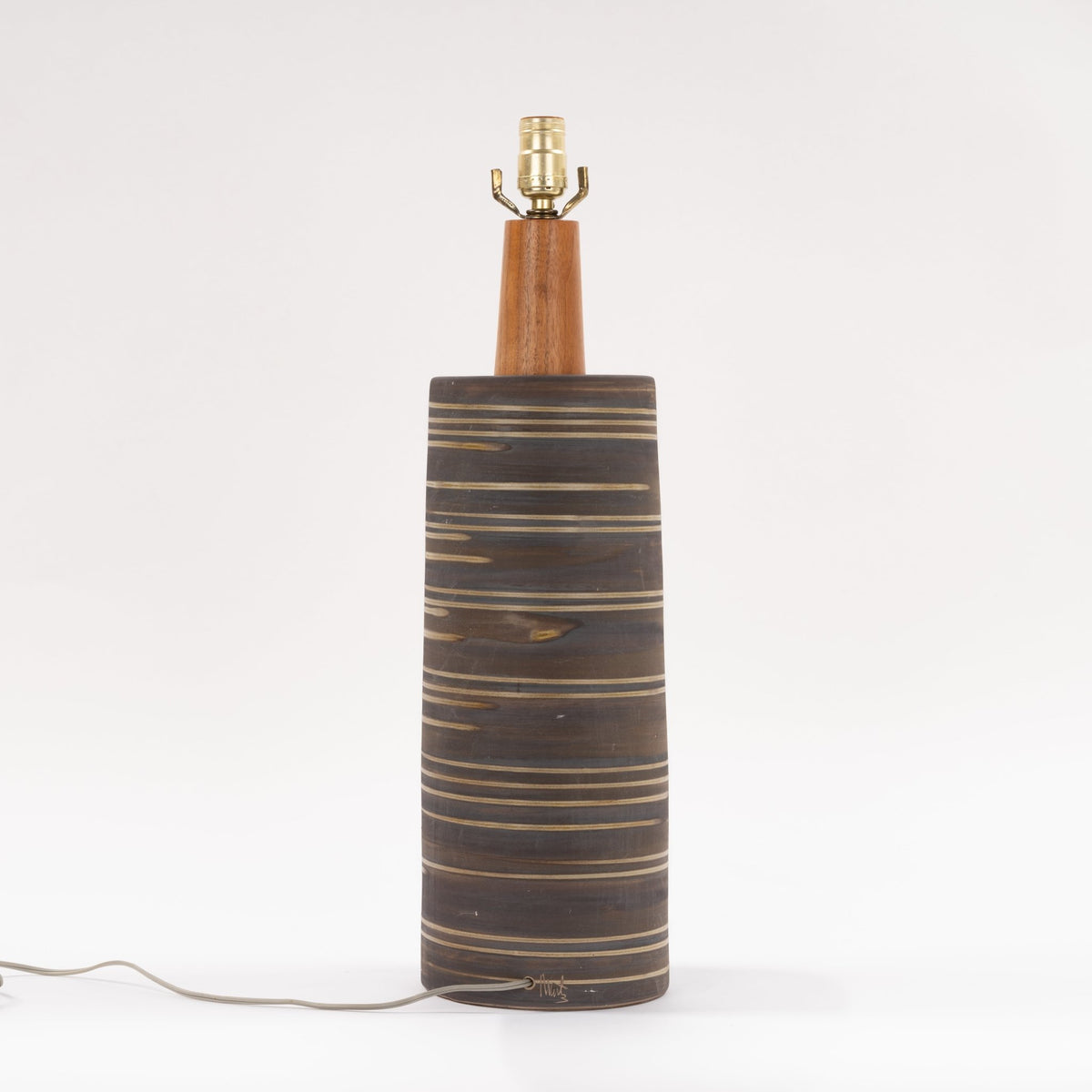 Gordon & Jane Martz Table Lamp with a dark striped ceramic cylinder base warm wood neck and exposed brass socket in mid century modern lighting style