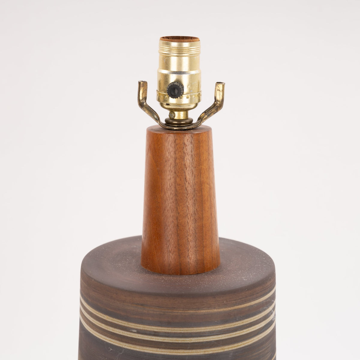 Gordon & Jane Martz Table Lamp close-up with a warm wood stem brass socket and striped ceramic base in mid century modern lighting style
