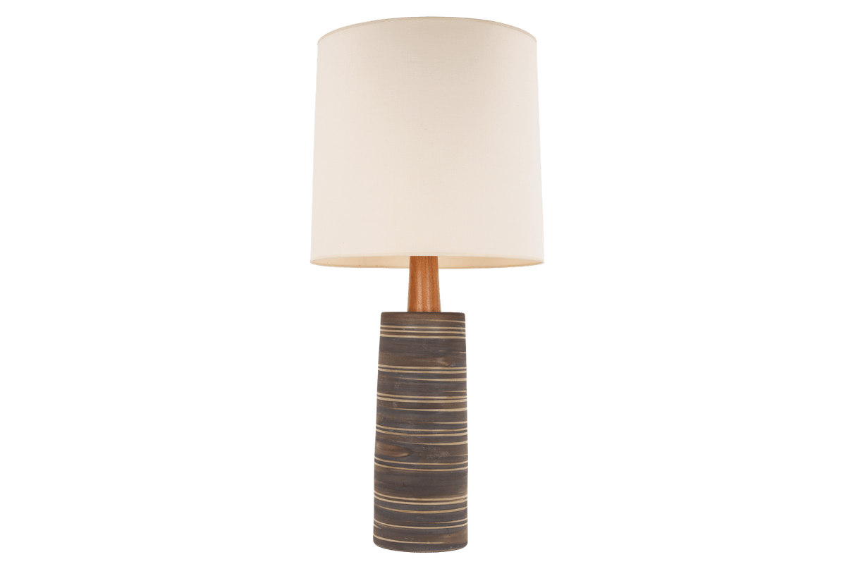 Gordon & Jane Martz Table Lamp with a striped ceramic base wooden stem and cream drum shade displayed against a black background in mid century modern lighting style
