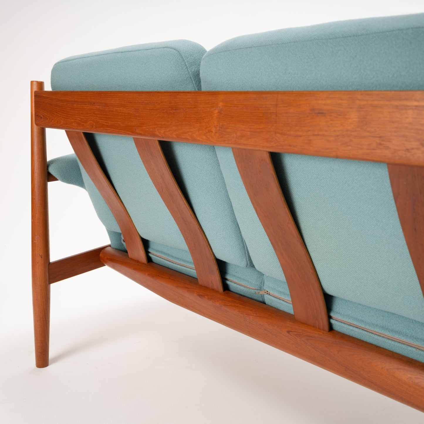 Grete Jalk Model 118 Teak Sofa featuring a sculpted teak frame with angled back supports and slender legs, upholstered in muted blue fabric, showcasing vintage Danish mid century modern seating design.