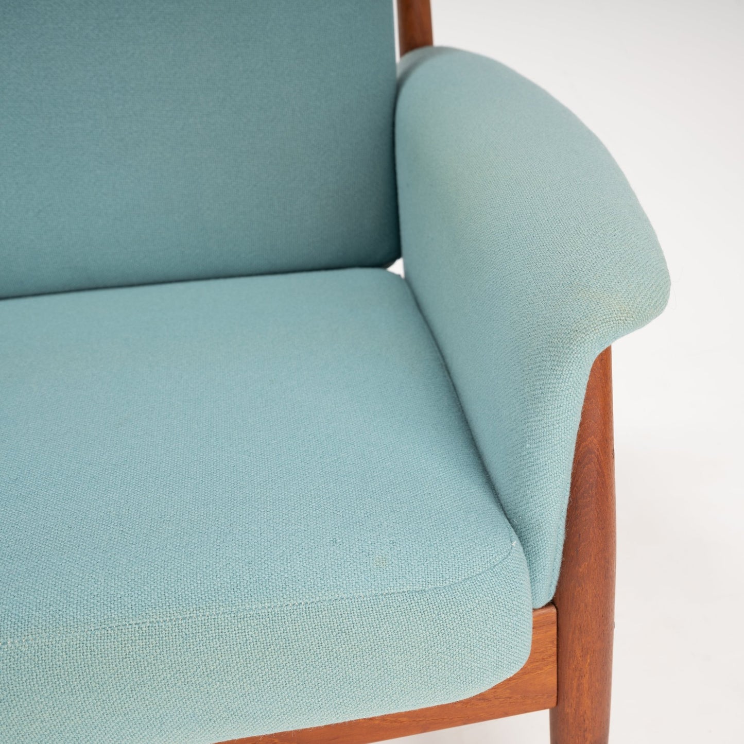 Grete Jalk Model 118 Teak Sofa featuring a finely crafted teak frame with gently curved armrest and plush light teal upholstery, exemplifying elegant mid century modern seating.