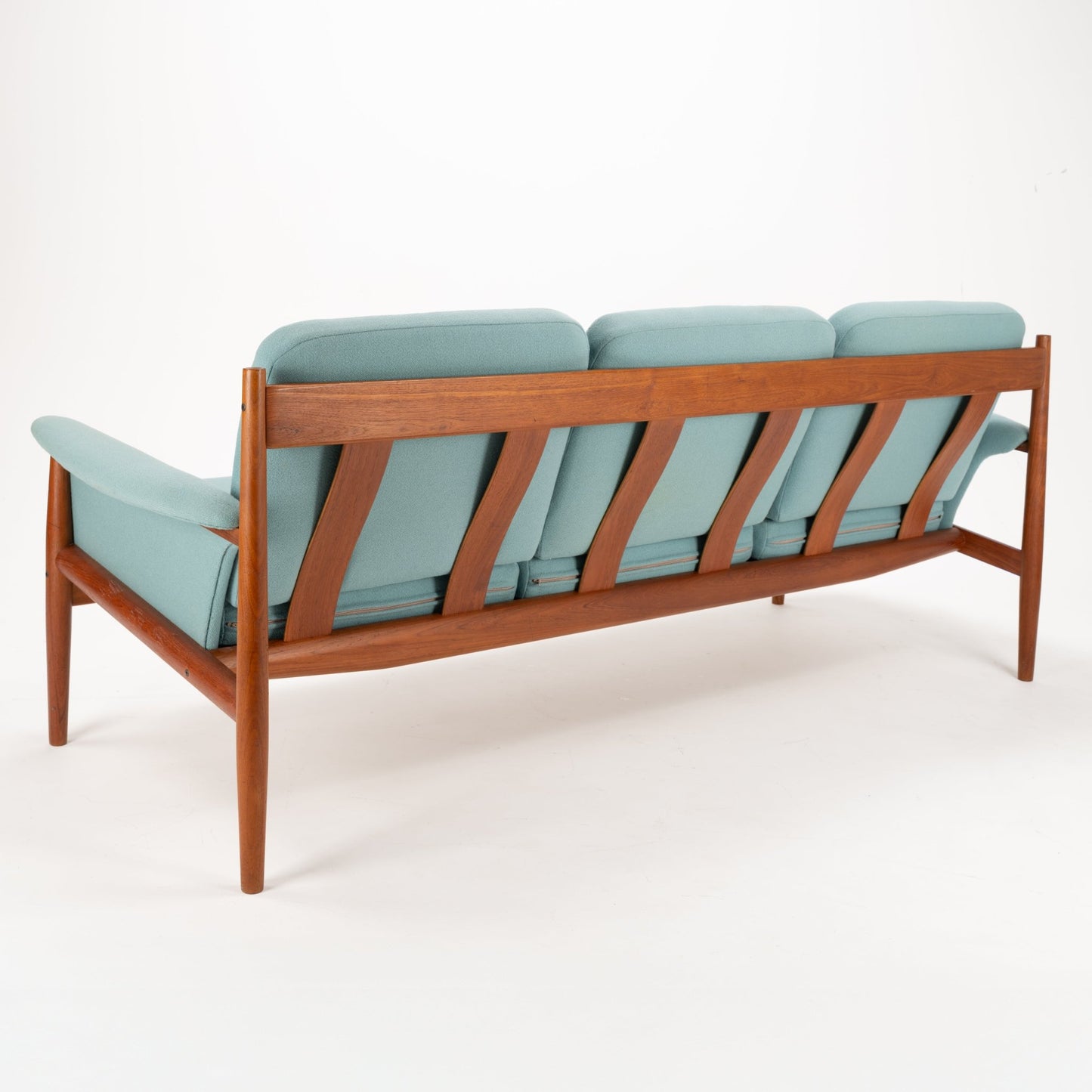 Grete Jalk Model 118 Teak Sofa featuring a sleek teak frame with angled back supports and tapered legs, upholstered in soft muted teal fabric, showcasing vintage Danish mid century modern seating design.
