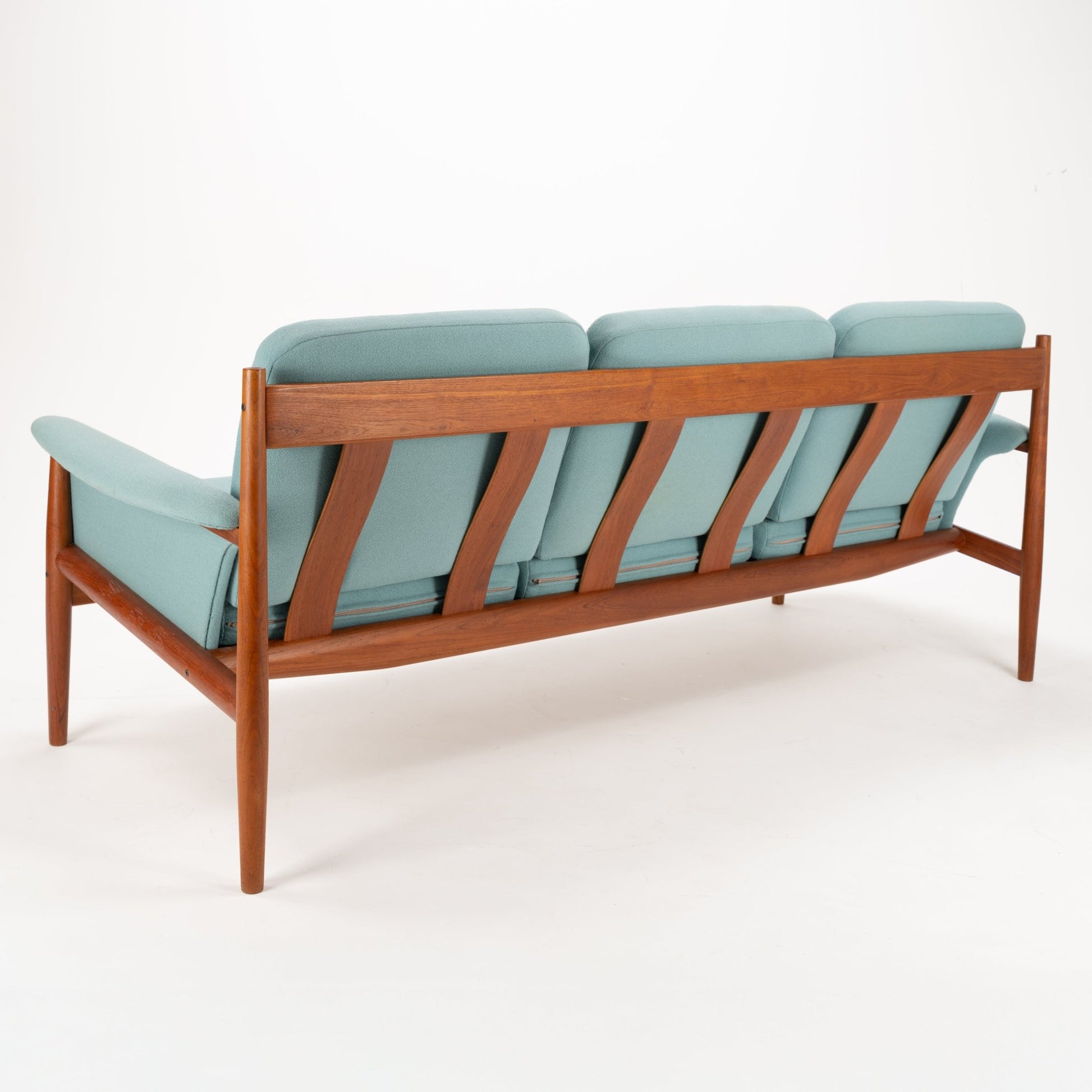 Grete Jalk Model 118 Teak Sofa featuring a sleek teak frame with angled back supports and tapered legs, upholstered in soft muted teal fabric, showcasing vintage Danish mid century modern seating design.