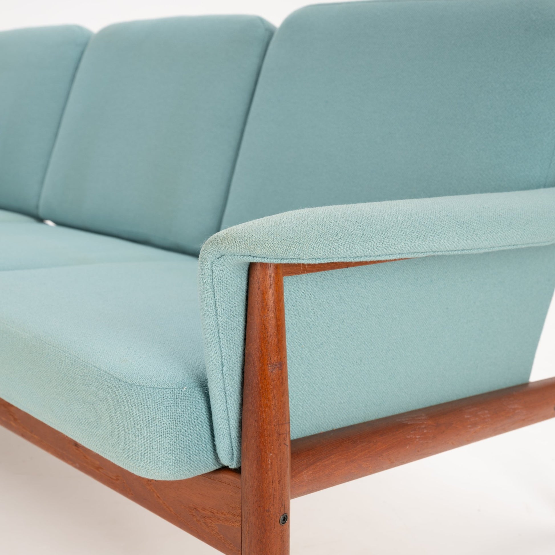 Grete Jalk Model 118 Teak Sofa with a sturdy teak frame and gently curved armrests, upholstered in soft muted seafoam fabric, embodying timeless vintage Danish mid century modern seating.