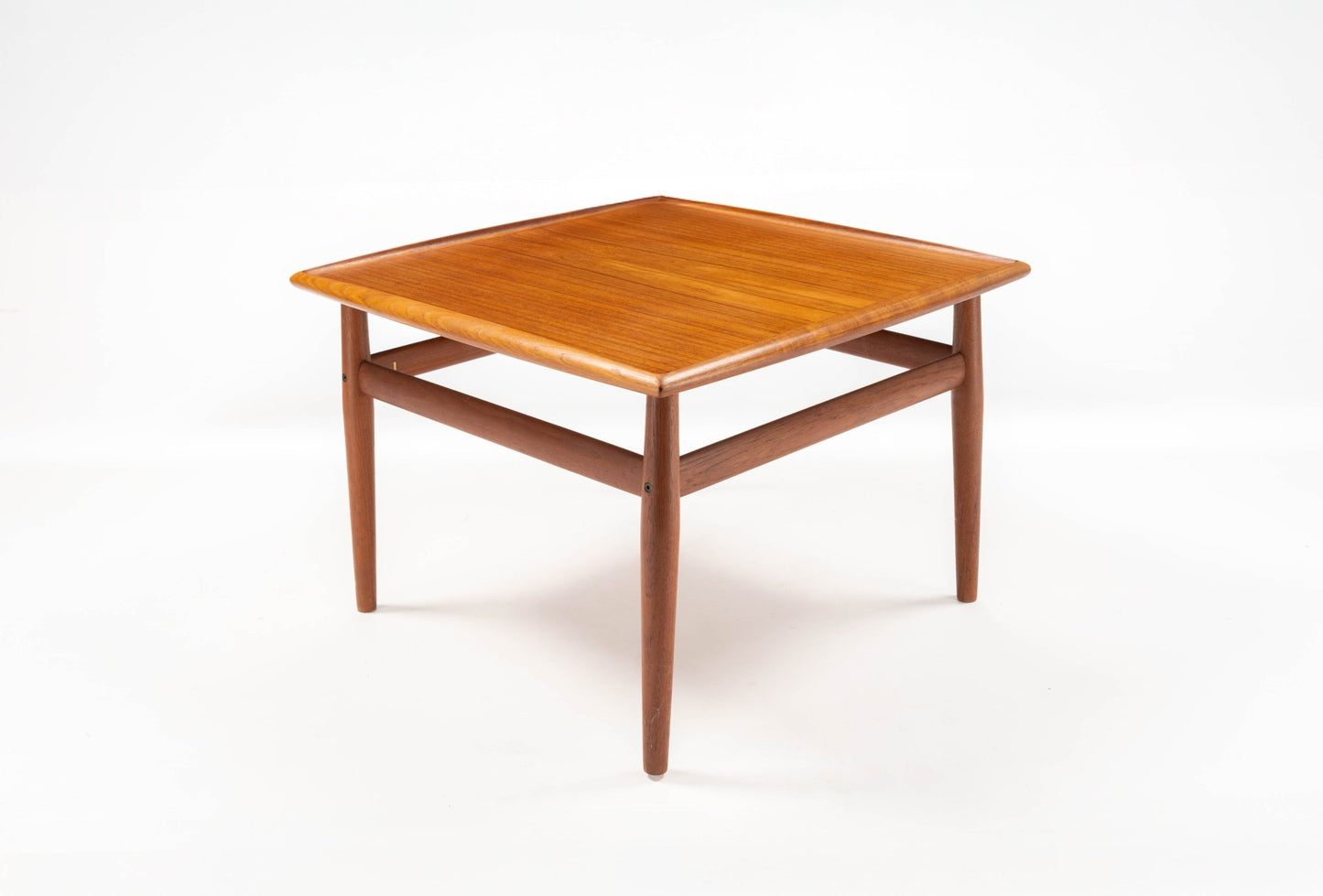Square mid-century modern teak side table with raised edge tabletop and turned tapered legs on white background