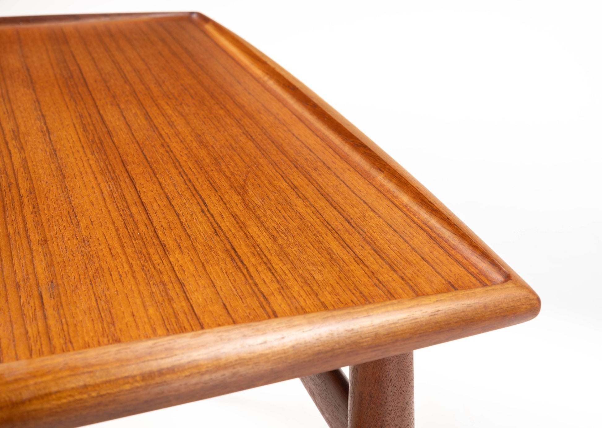 Close-up of mid-century modern Grete Jalk teak side table with square raised edge tabletop and turned legs