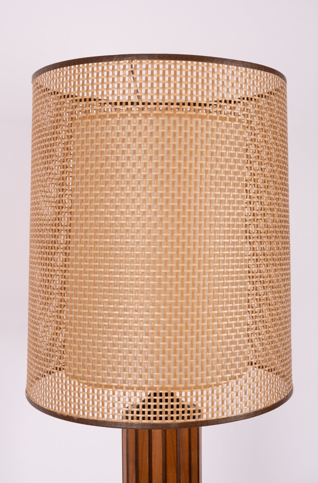 Close-up of 1960s Gruvwood fluted walnut table lamp with cane exterior shade and center diffuser