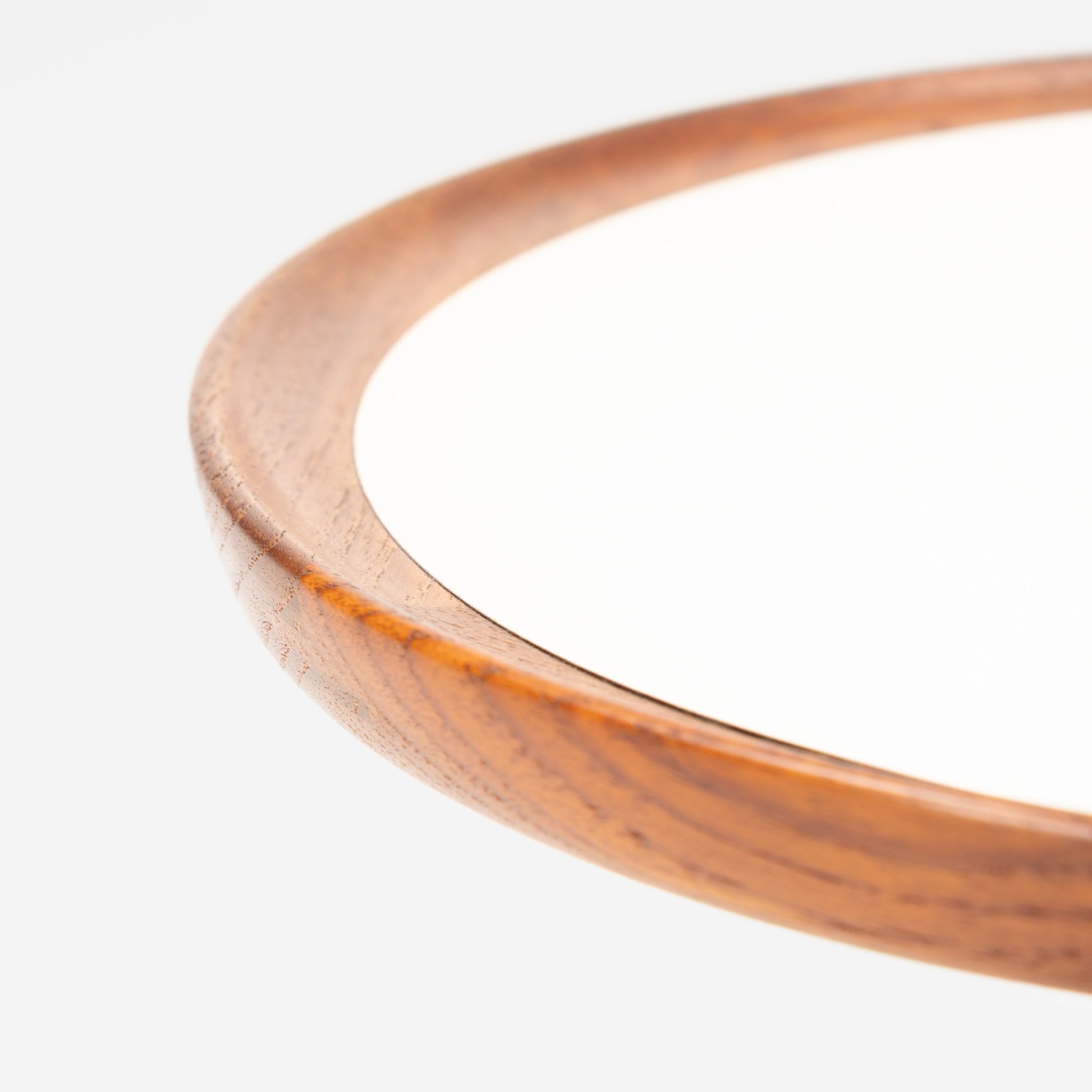 Hans Andersen Teak Tripod Side Table with a close-up of the smooth teak rim encircling a white surface, highlighting fine wood grain and refined mid century modern craftsmanship.