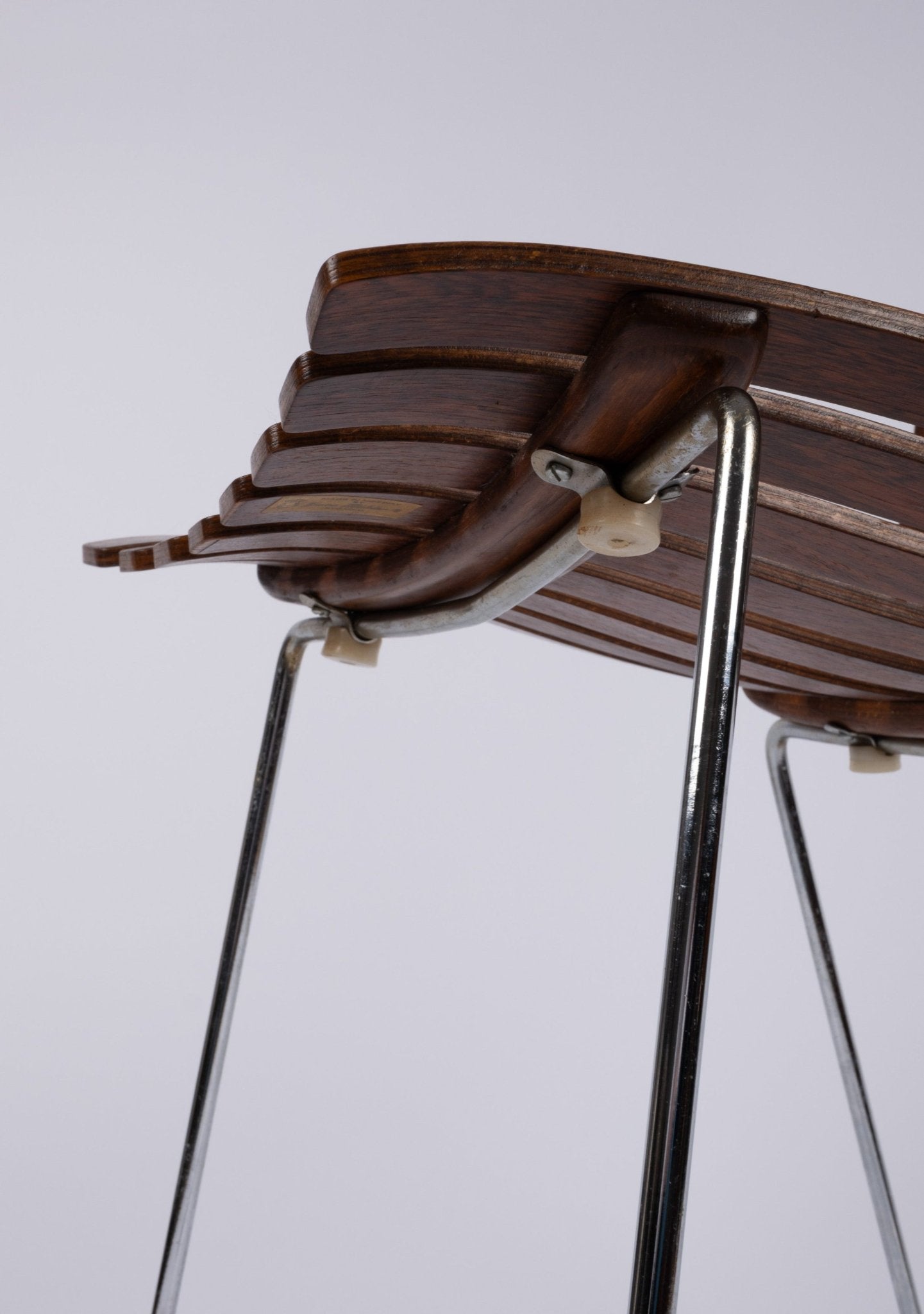 Close-up of Hans Brattrud rosewood dining chair seat with curved laminated slats and chrome legs from the 1960s