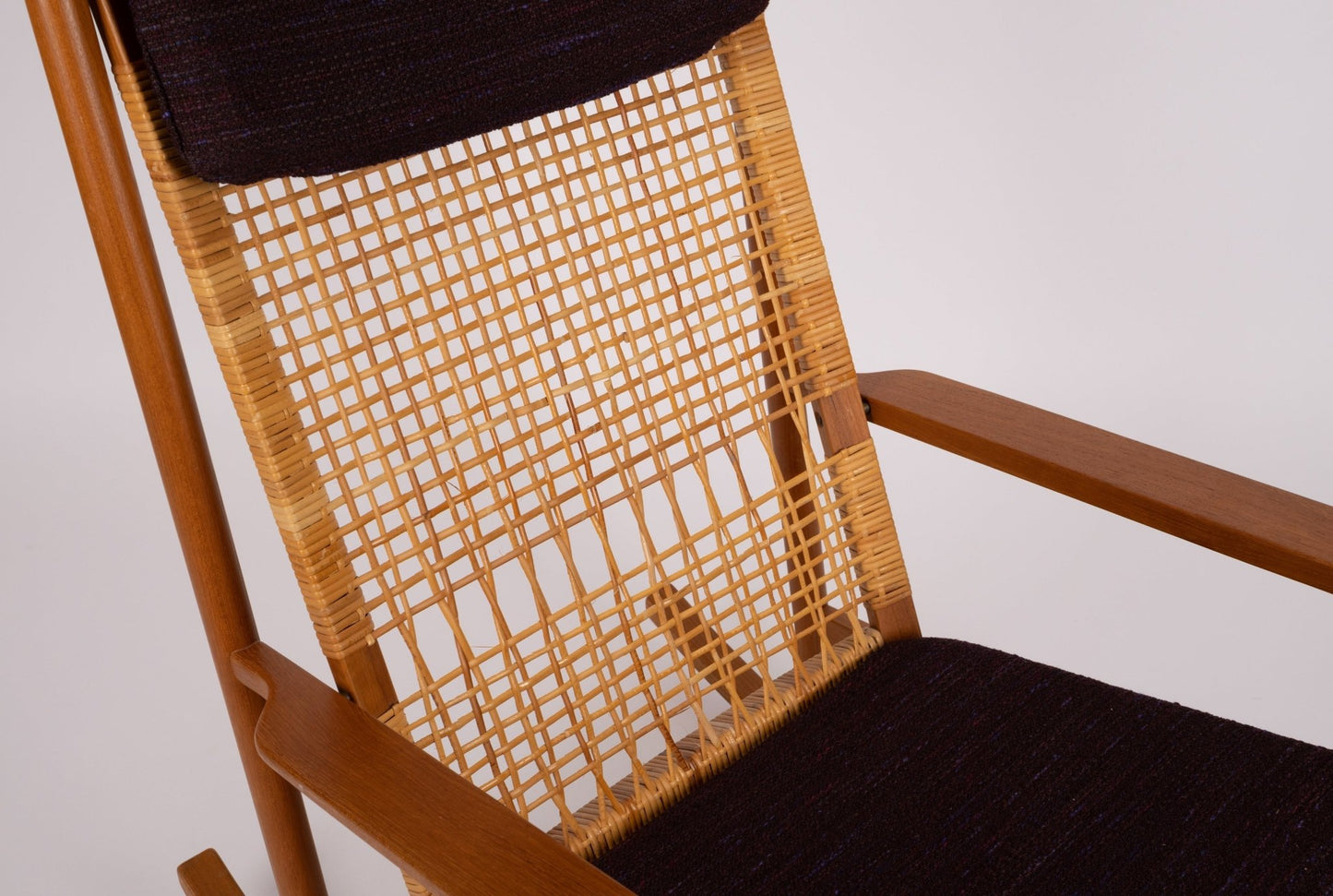 Close-up of Hans Olsen 1960s Danish teak rocking chair with new cane back and dark upholstered cushions