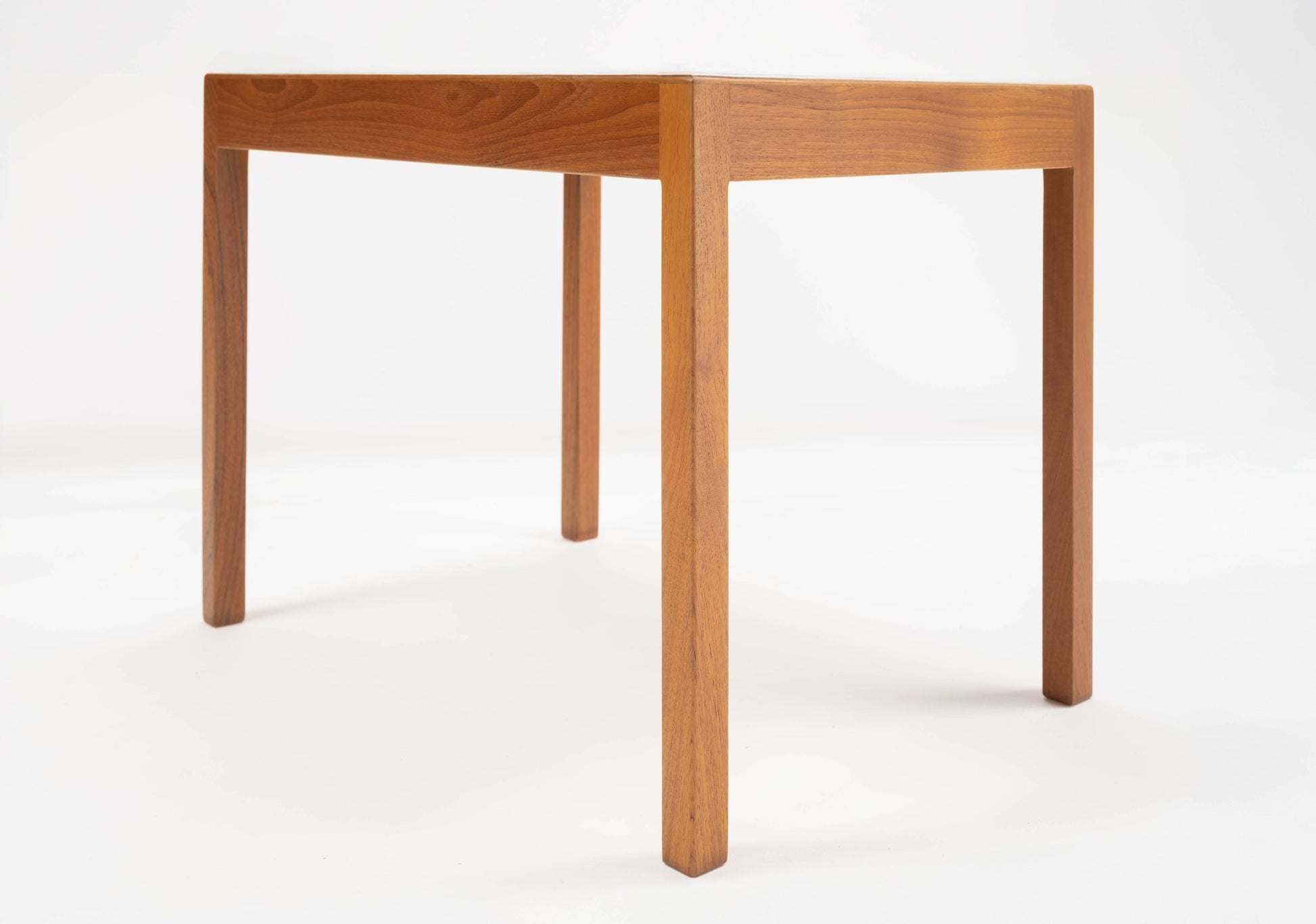 Pair of Hans Wegner Danish teak side tables with minimalist clean lines and tapered legs on white background