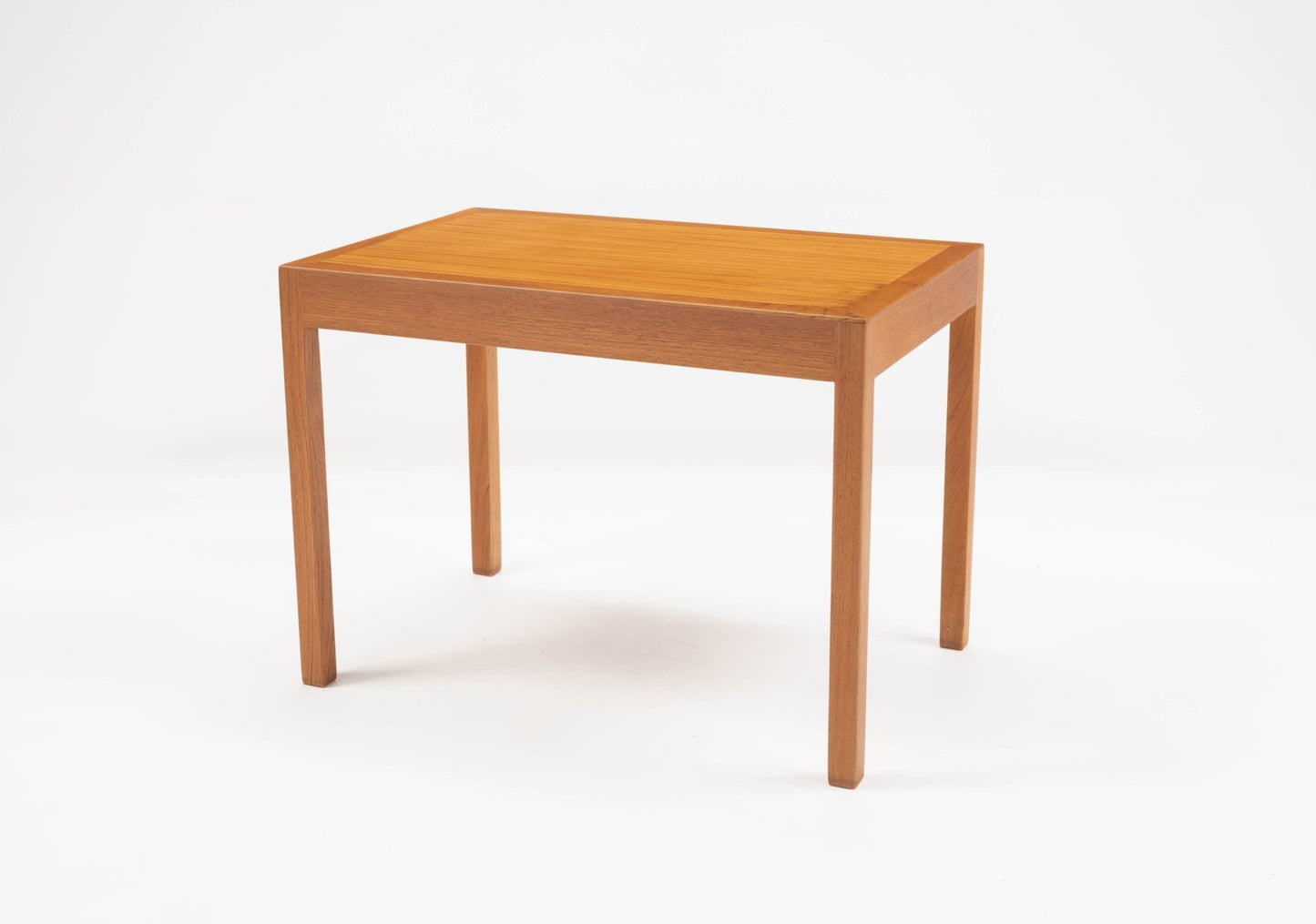 Hans Wegner mid-century modern teak side table with rectangular top and slender tapered legs on white background