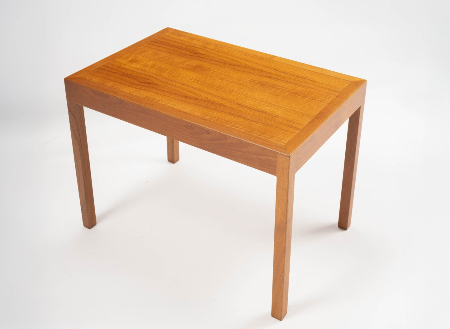Pair of Danish teak side tables by Hans Wegner with minimalist rectangular tops and tapered legs on white background.
