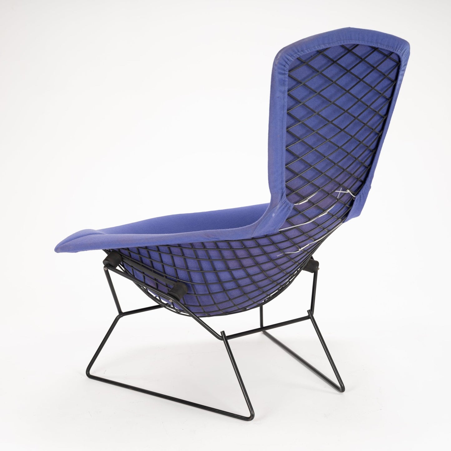 Lounge chair with dark metal wireframe base and diamond-patterned mesh backrest upholstered in blue fabric