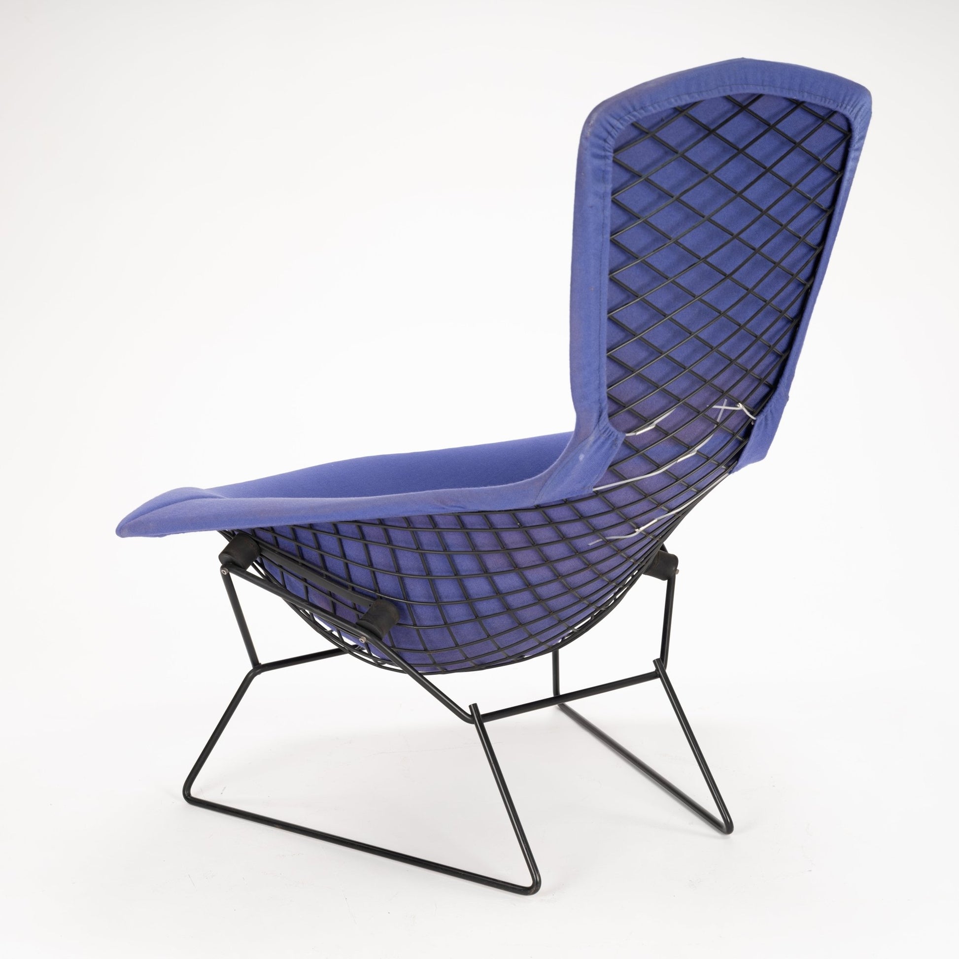 Lounge chair with dark metal wireframe base and diamond-patterned mesh backrest upholstered in blue fabric