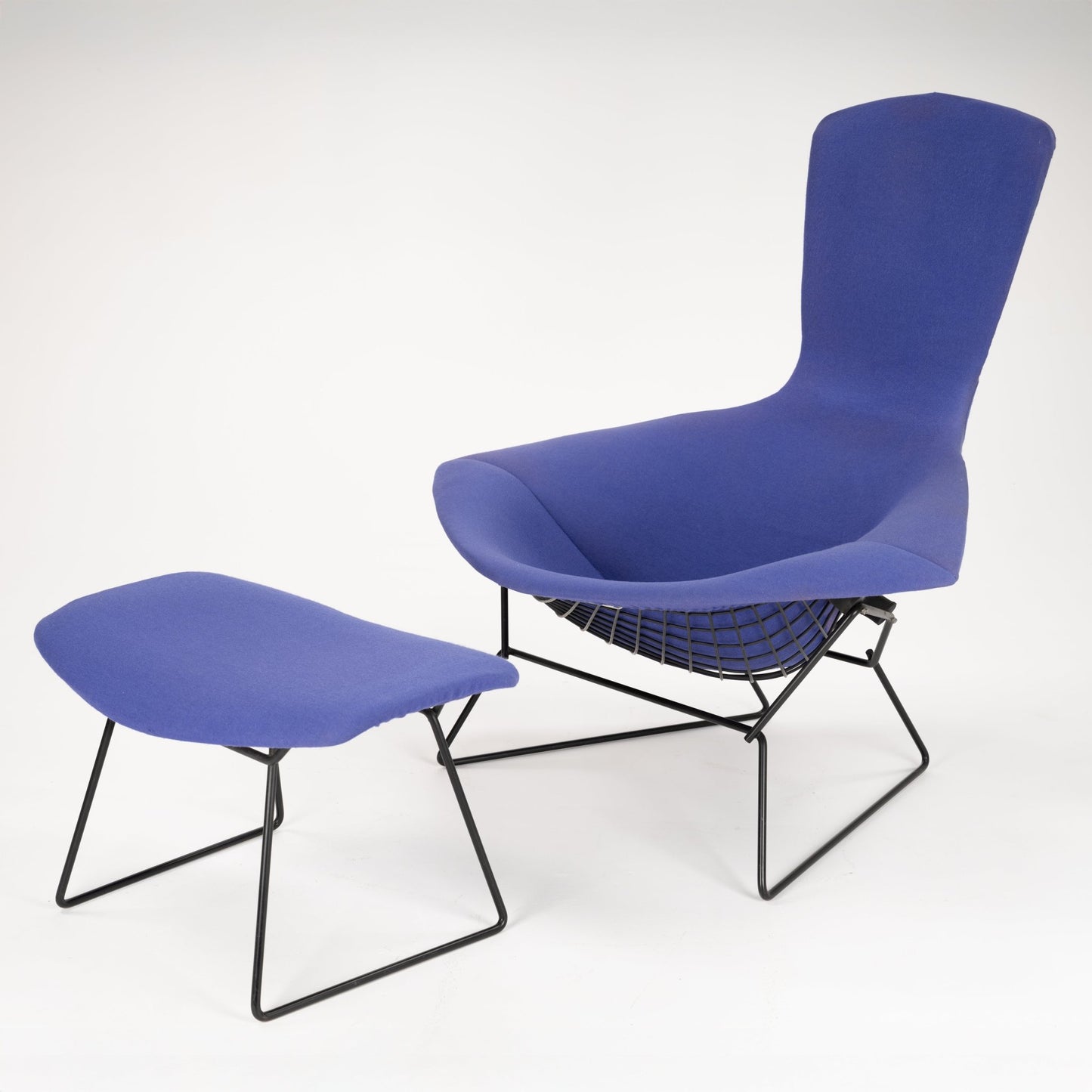 Contemporary lounge chair and matching ottoman with blue fabric upholstery and black wireframe base design