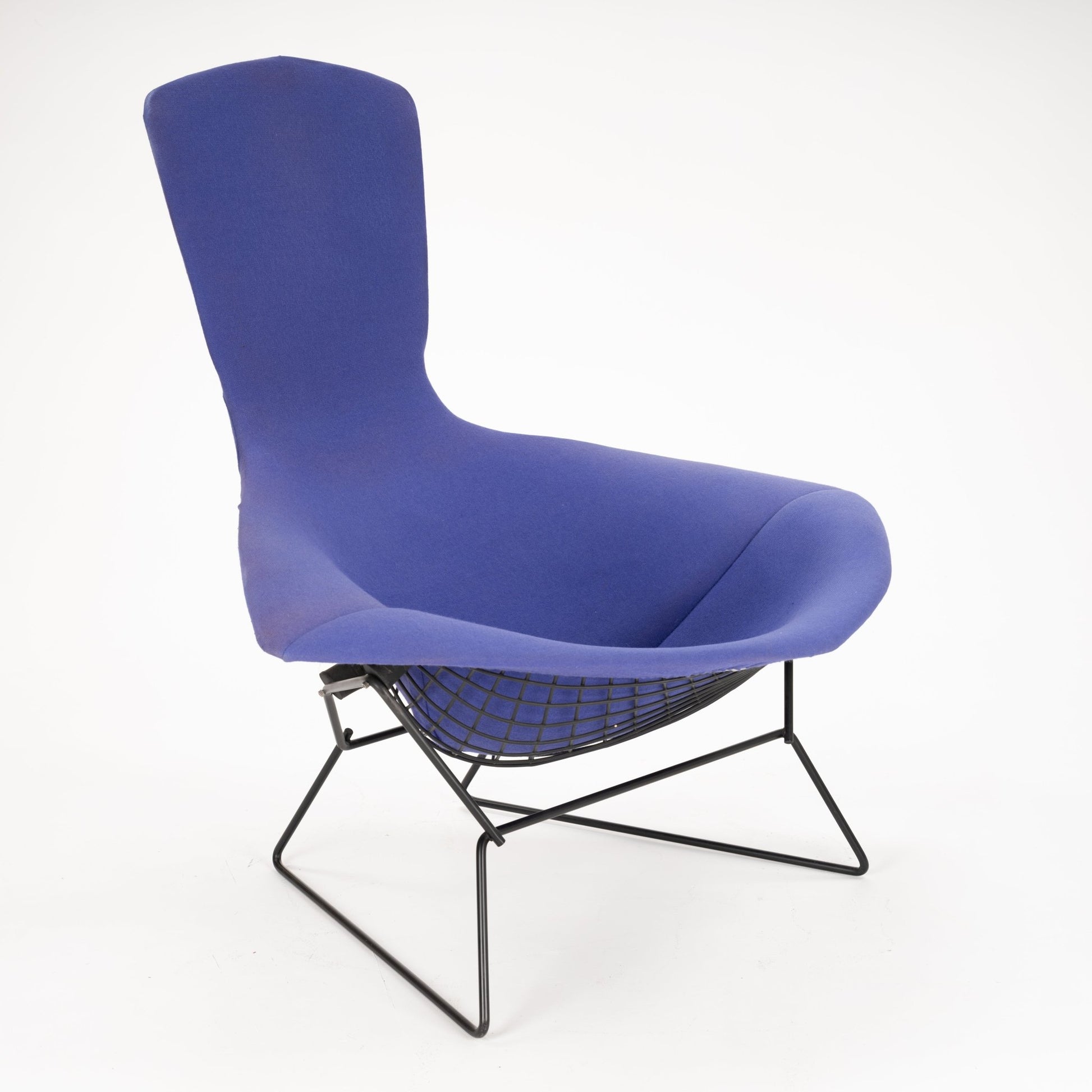 Modern lounge chair with tall backrest and contoured blue fabric seat supported by black metal wireframe base