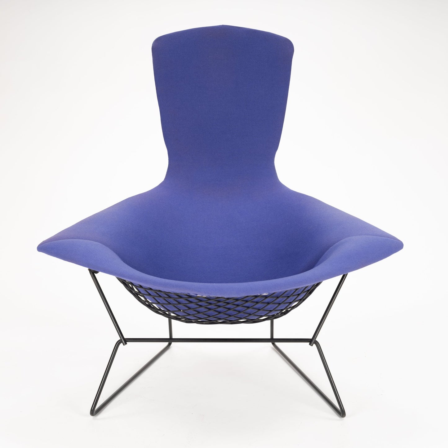 Wide modern lounge chair with deep blue fabric upholstery and black wireframe base and mesh seat support