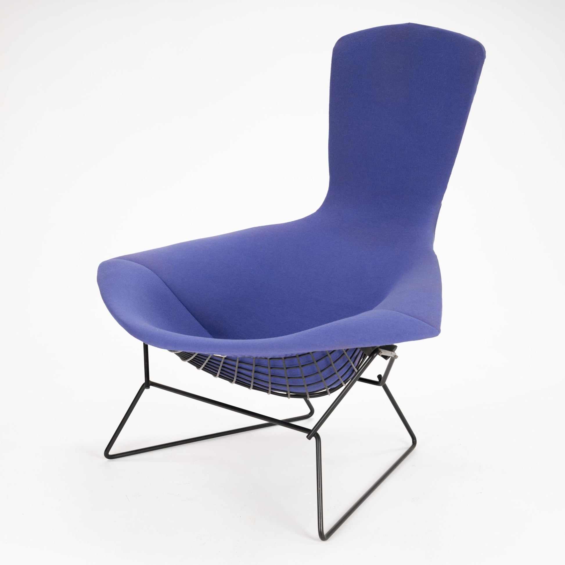 Blue upholstered lounge chair with high backrest and black wireframe base with mesh support beneath seat