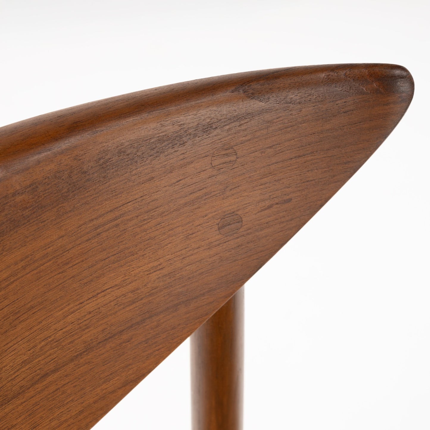 Close-up of smooth teak wood grain and rounded edge detail on the sculpted crescent backrest of Model 316 chair