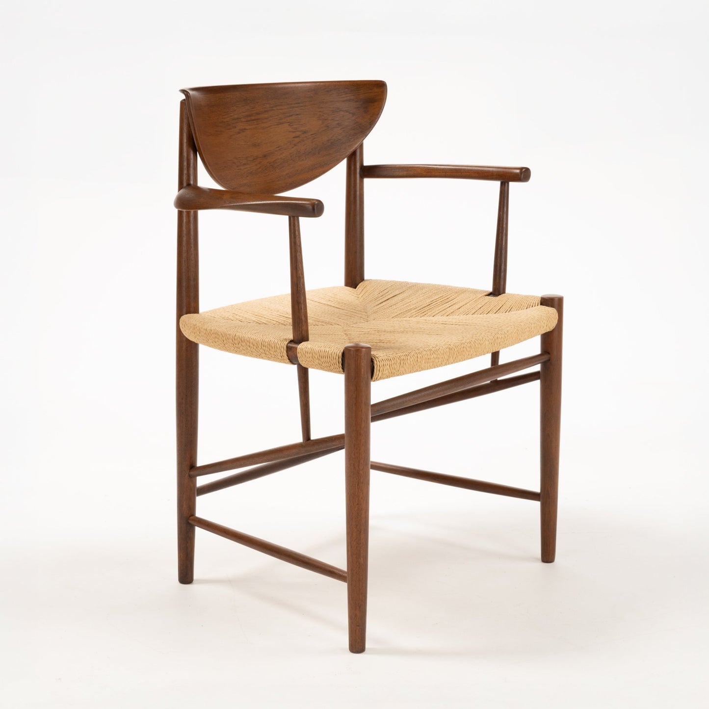 Three-quarter view of Hvidt & Molgaard Model 317 chair with curved teak backrest and woven natural fiber seat