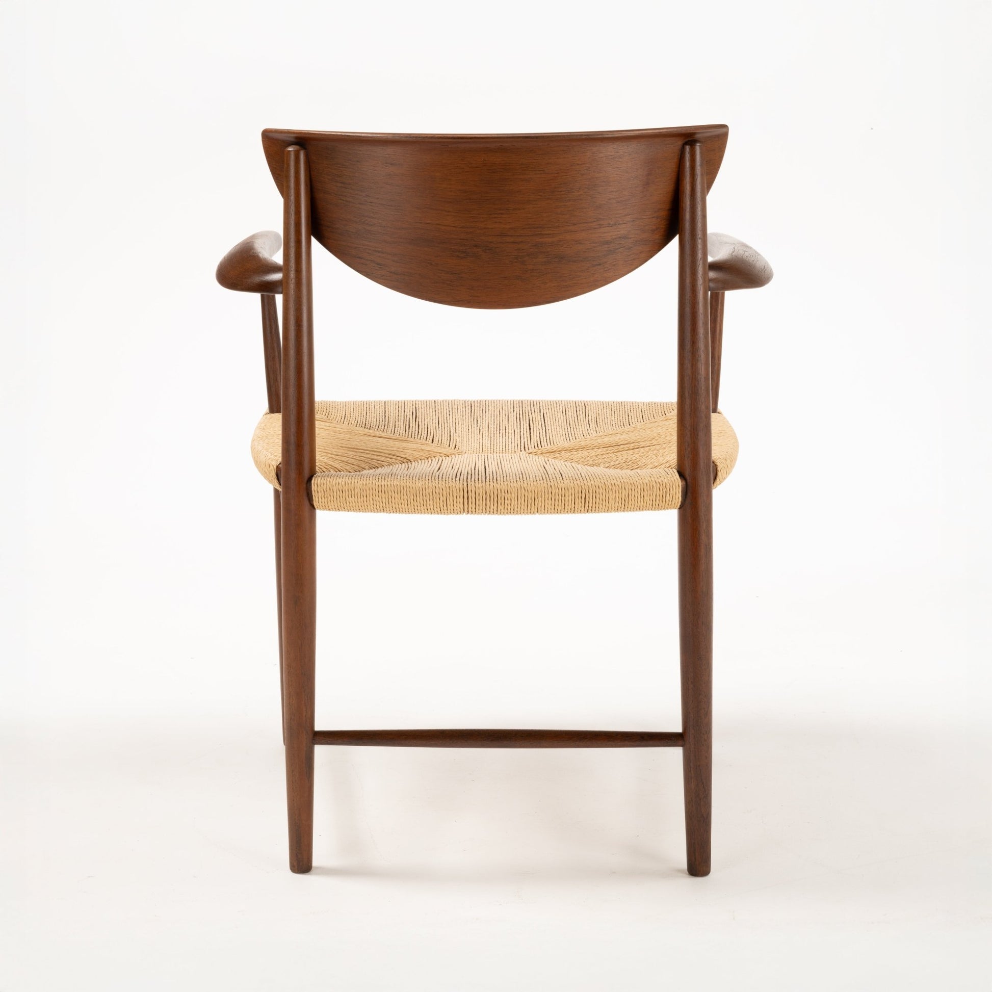Rear view of Hvidt & Molgaard Model 317 chair with sculpted teak backrest and woven natural fiber seat on solid wood frame