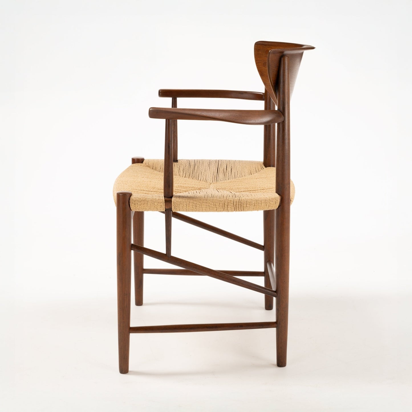 Side view of Hvidt & Molgaard Model 317 chair with curved teak armrests and woven natural fiber seat on solid wood frame