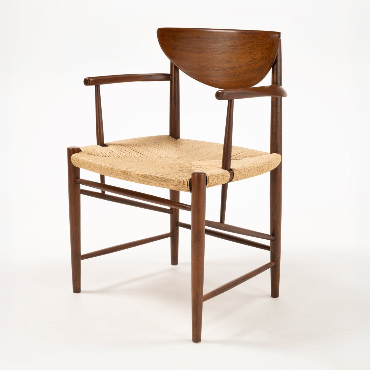 Three-quarter view of Hvidt & Molgaard Model 317 chair with curved teak backrest and woven natural fiber seat