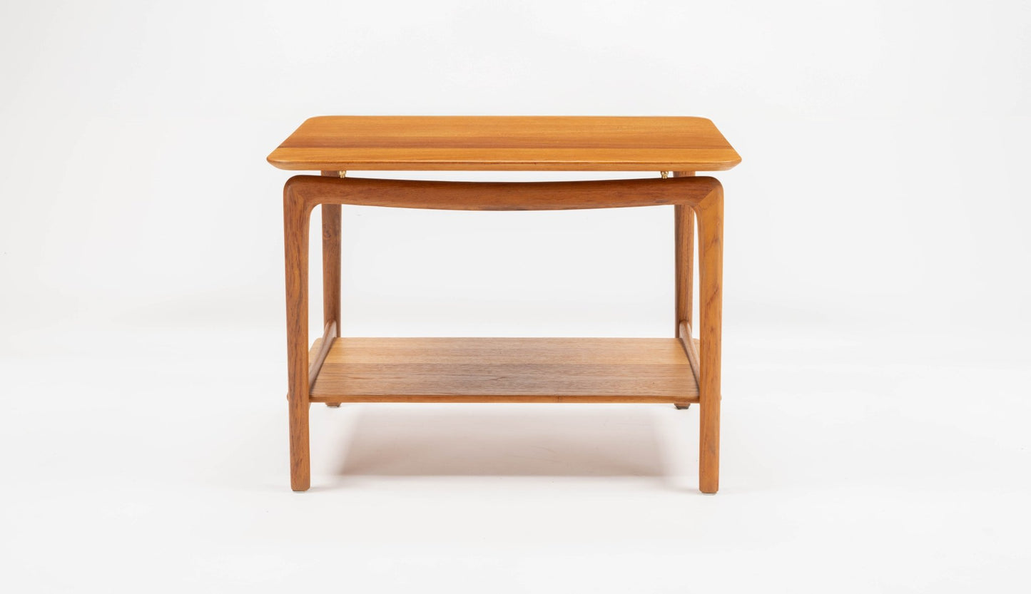 Mid-century modern Danish teak side table by Hvidt & Molgaard with sculpted legs and brass spacers on white background