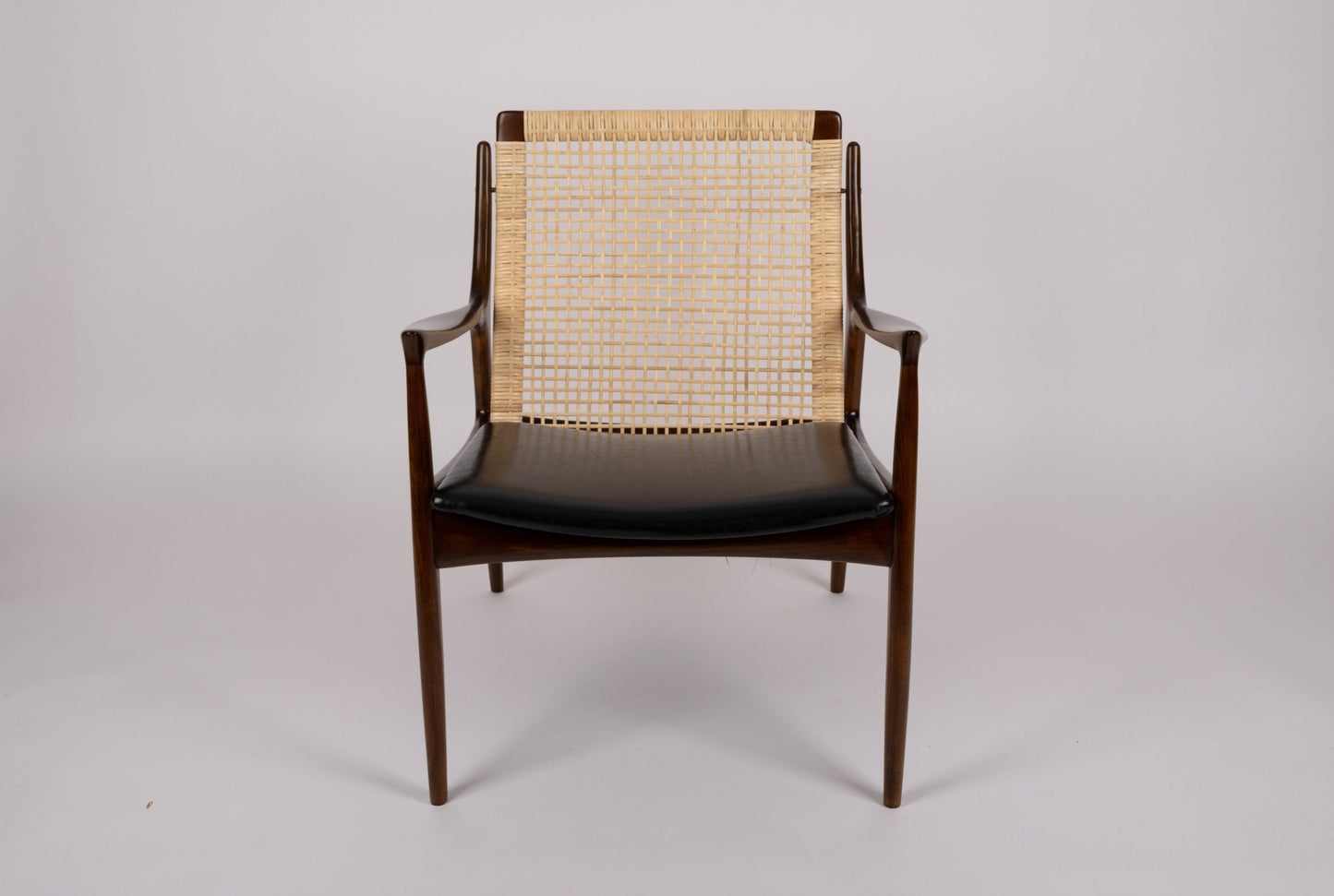 Ib Kofod Larsen cane armchair model 18-15 with solid teak frame and original faux leather seat from Denmark.
