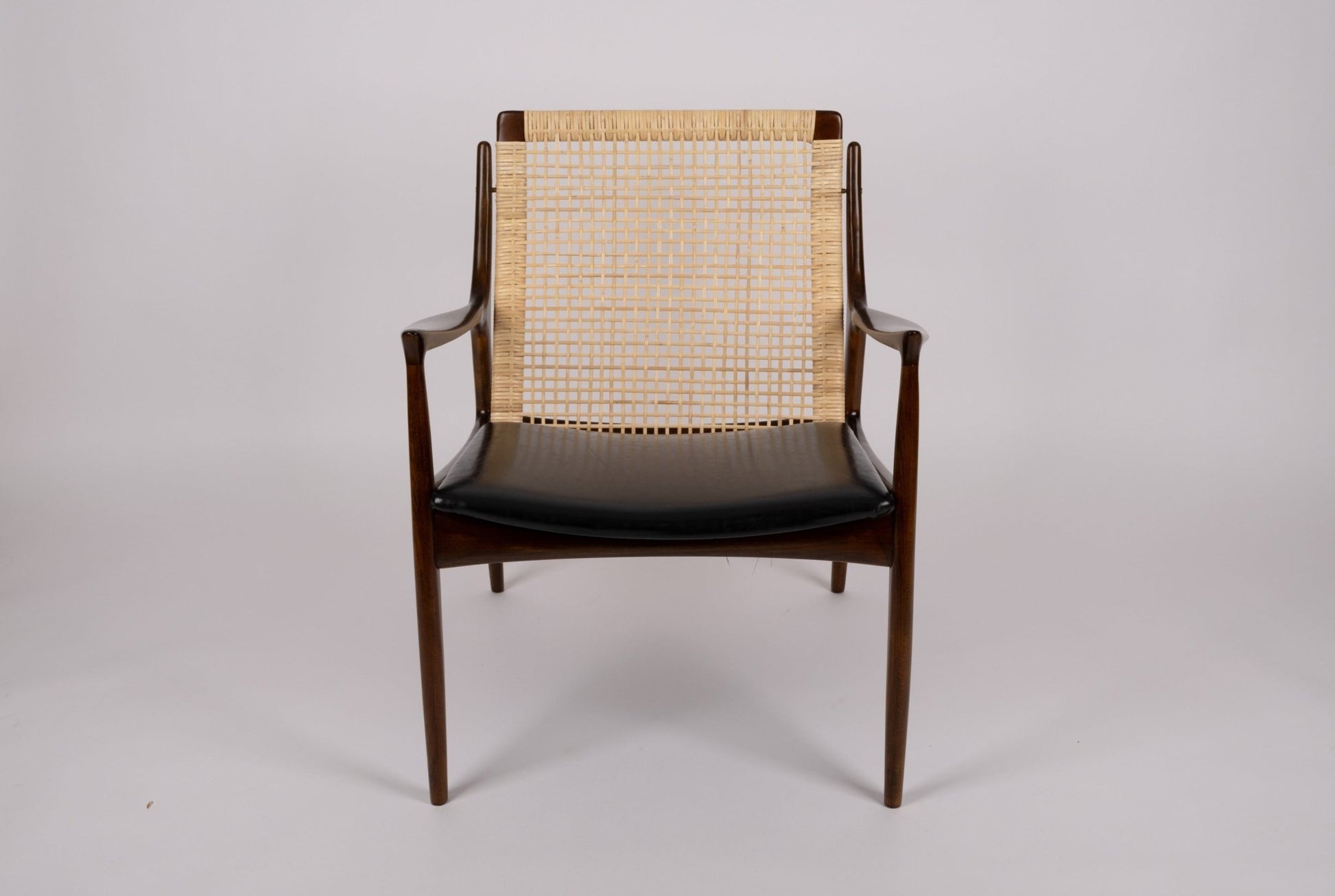 Ib Kofod Larsen cane armchair model 18-15 with solid teak frame and original faux leather seat from Denmark.